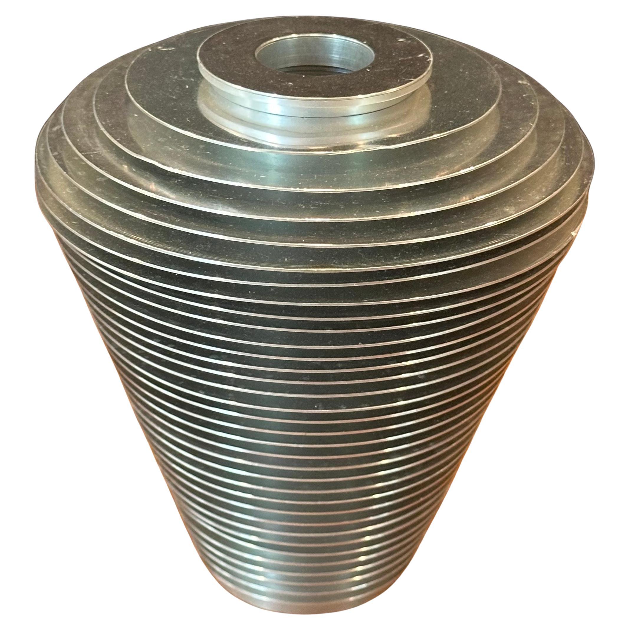 Très beau vase Saturne d'Avedis Baghsarian, composé d'anneaux d'aluminium gradués et empilés entourant un noyau cylindrique en aluminium. Cette série a été conçue pour se démonter et se remonter dans des configurations presque infinies. Original,