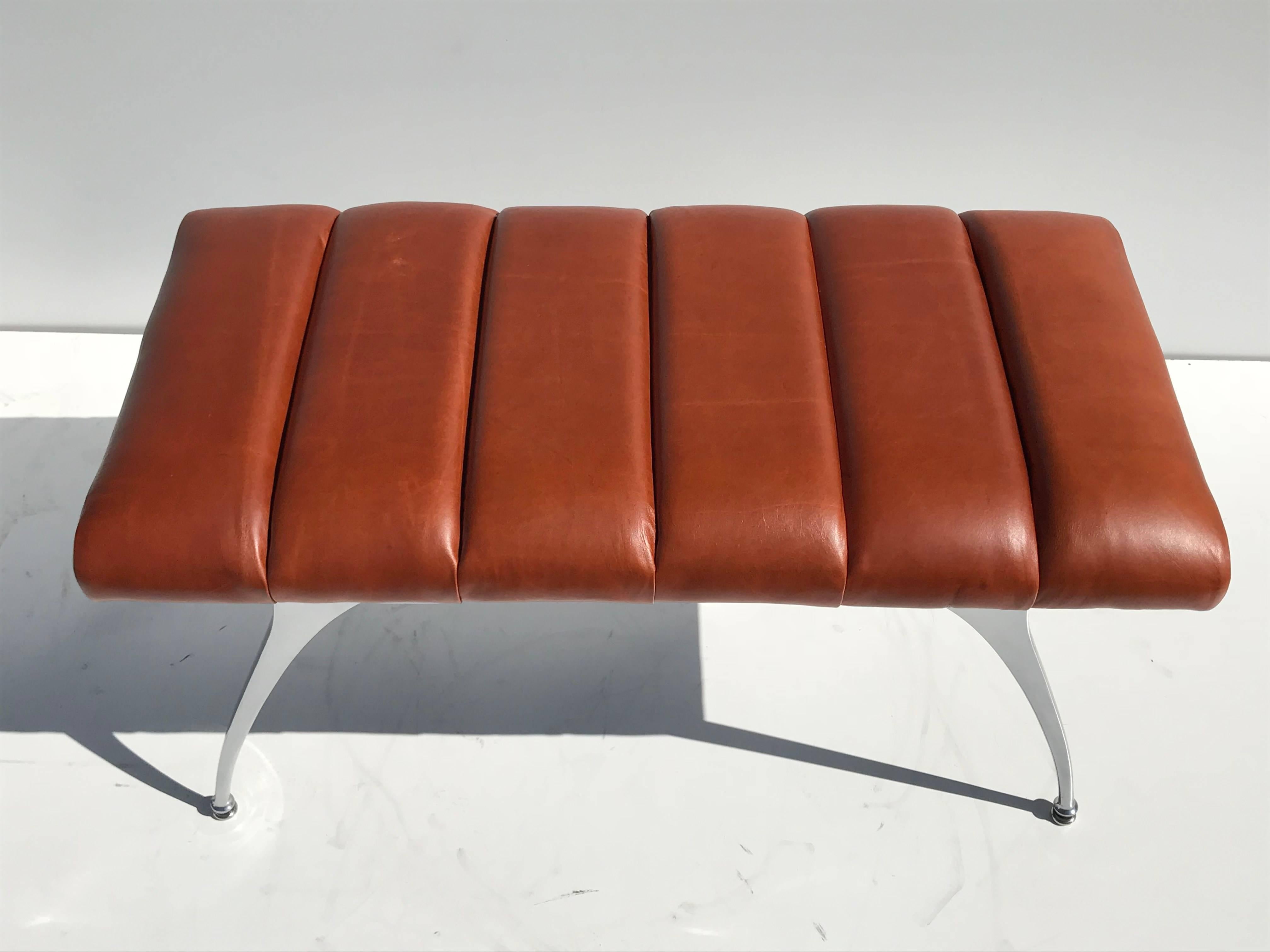Modernist aluminum bench in channel tufted vintage cognac leather.
Legs are vintage from 1960's
Upholstery is brand new with vintage leather.
1stDibs offers flat rate shipping for $369 but we can ship it by UPS Ground for $225