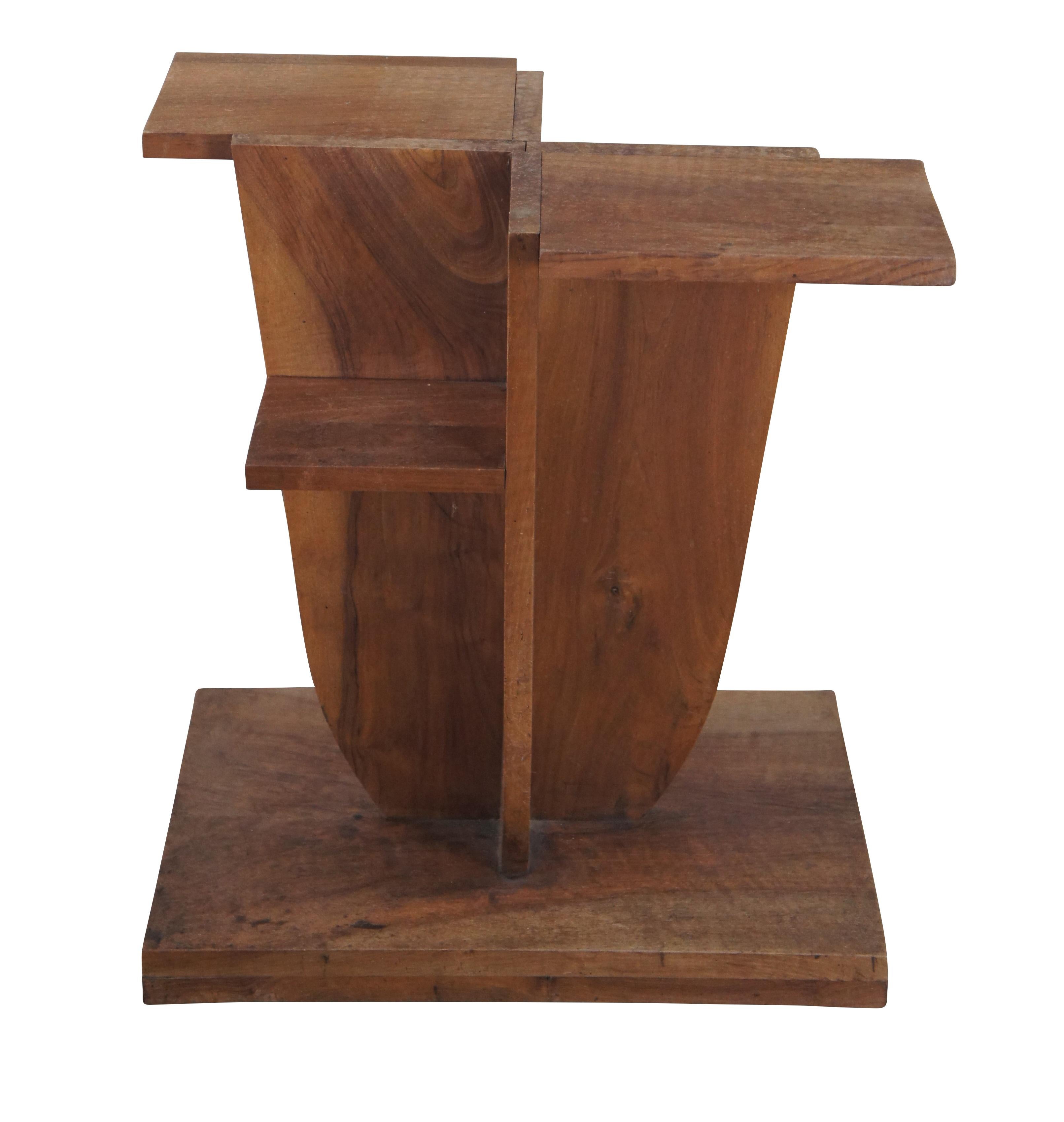 20th Century Art Deco style tiered sculpture stand or side table.  Made from American walnut with an abstract form featuring an upper surface and two shelves on each side. The piece is set over a plinth base.  A piece of glass could be added to use