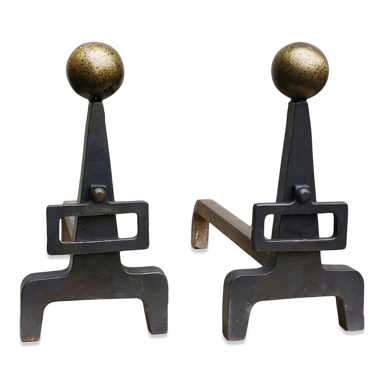 Modernist wrought iron andirons with buckle
Hammered brass balls on top of each andiron.
 