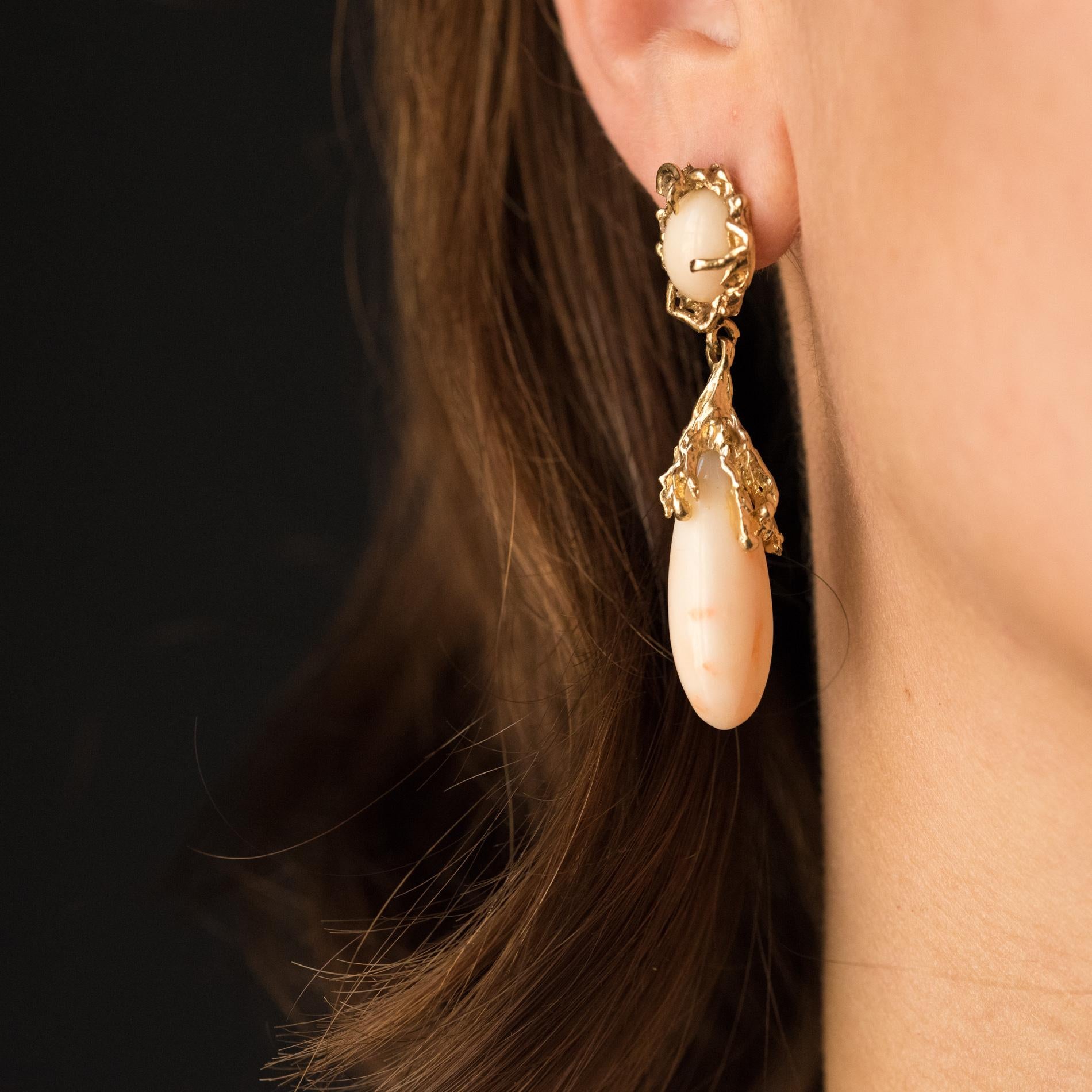 For pierced ears.
Earrings in 14 Karats yellow gold.
These splendid earrings with asymmetrical lines are set with claws of a angel skin coral cabochon in a gnarled decor, chiseled, like a branch that set the gem. As a tassel, a drop of angel skin