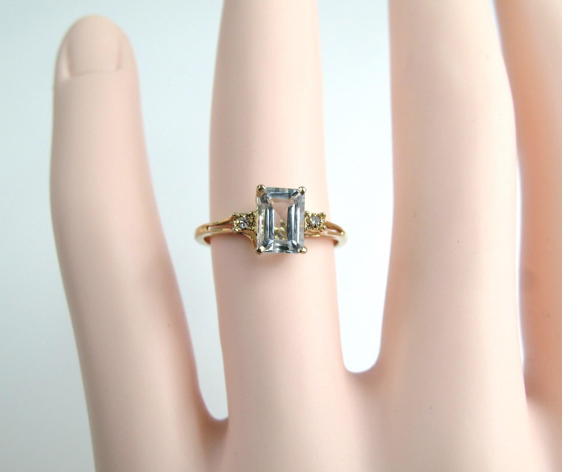 Sleek Modern Aquamarine & Diamond Ring. Prong-set Aquamarine Emerald-cut stone flanked by 1 Diamond on each side. The ring is a size a 6 and can be sized by us or your jeweler. Be sure to check our storefront for more fabulous pieces from this