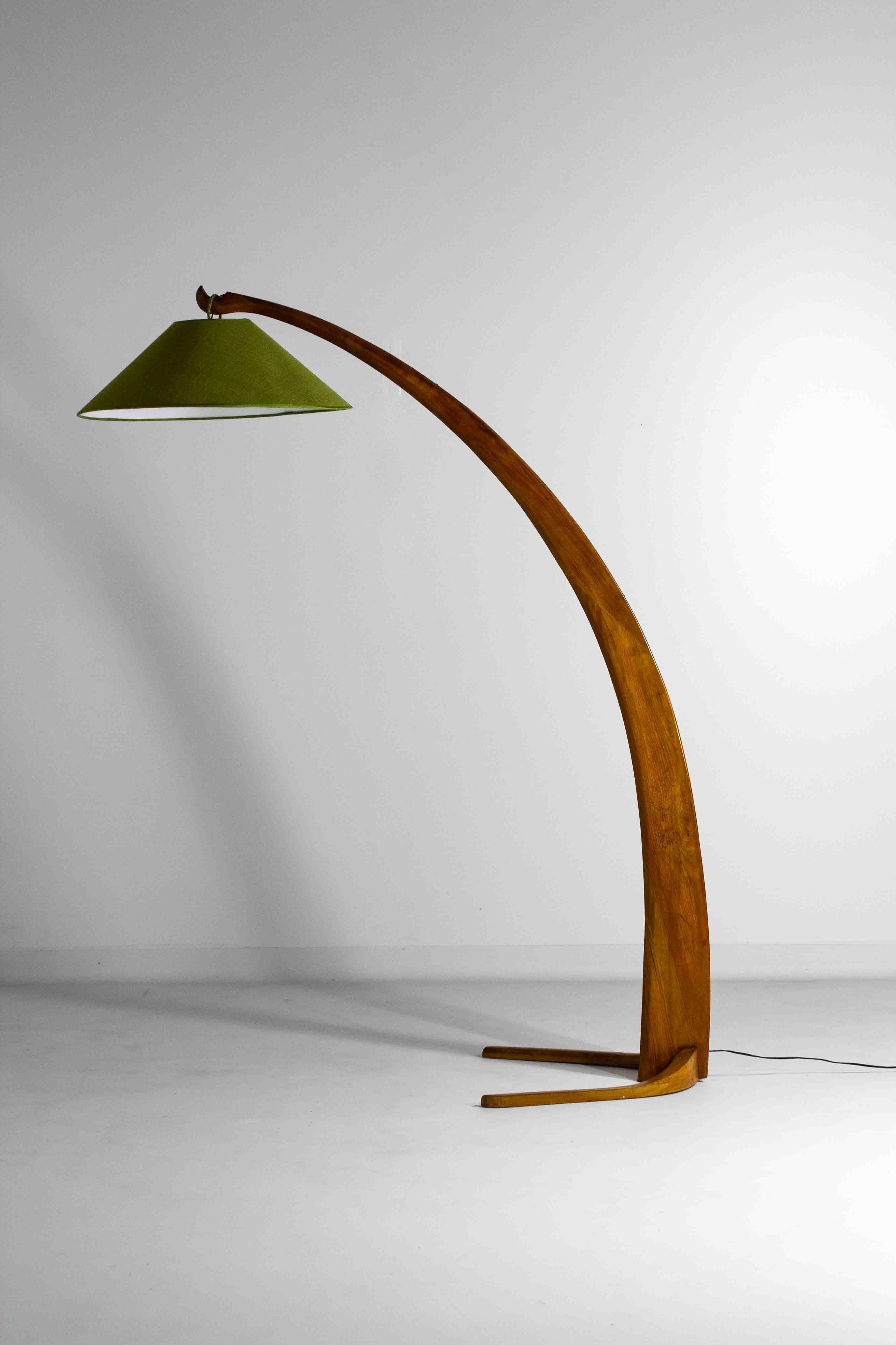 This modernist floor lamp from 1950s Italy features a gracefully arched design crafted from bent walnut wood. The large, curved stem supports a green shade, creating a nice play between calm and striking colors.
