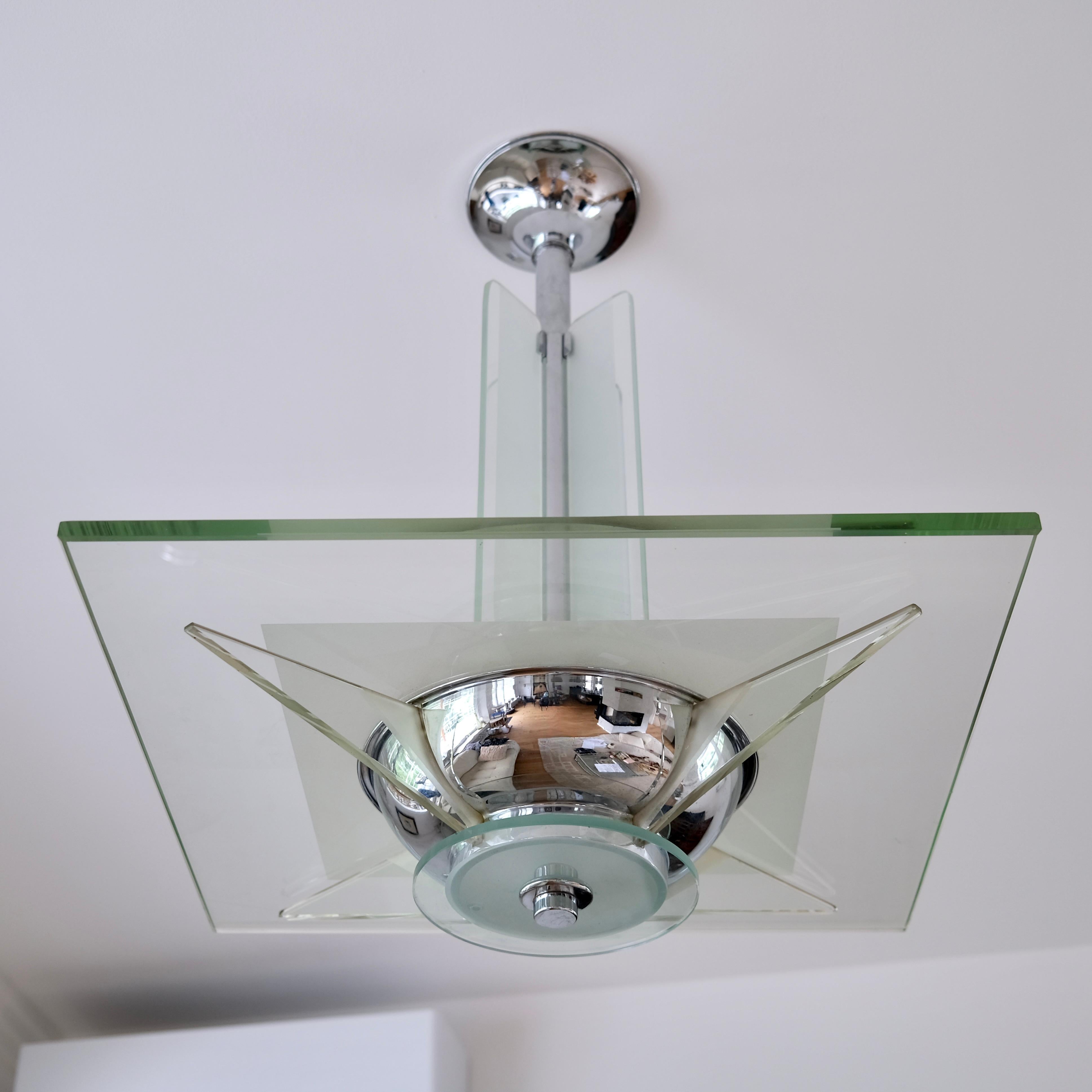 Encarnando la audaz elegancia del movimiento modernista, esta excepcional lámpara de techo Art Decó de los años 30 combina una elegante geometría con materiales de alta calidad para crear una pieza central atemporal. La característica más destacada