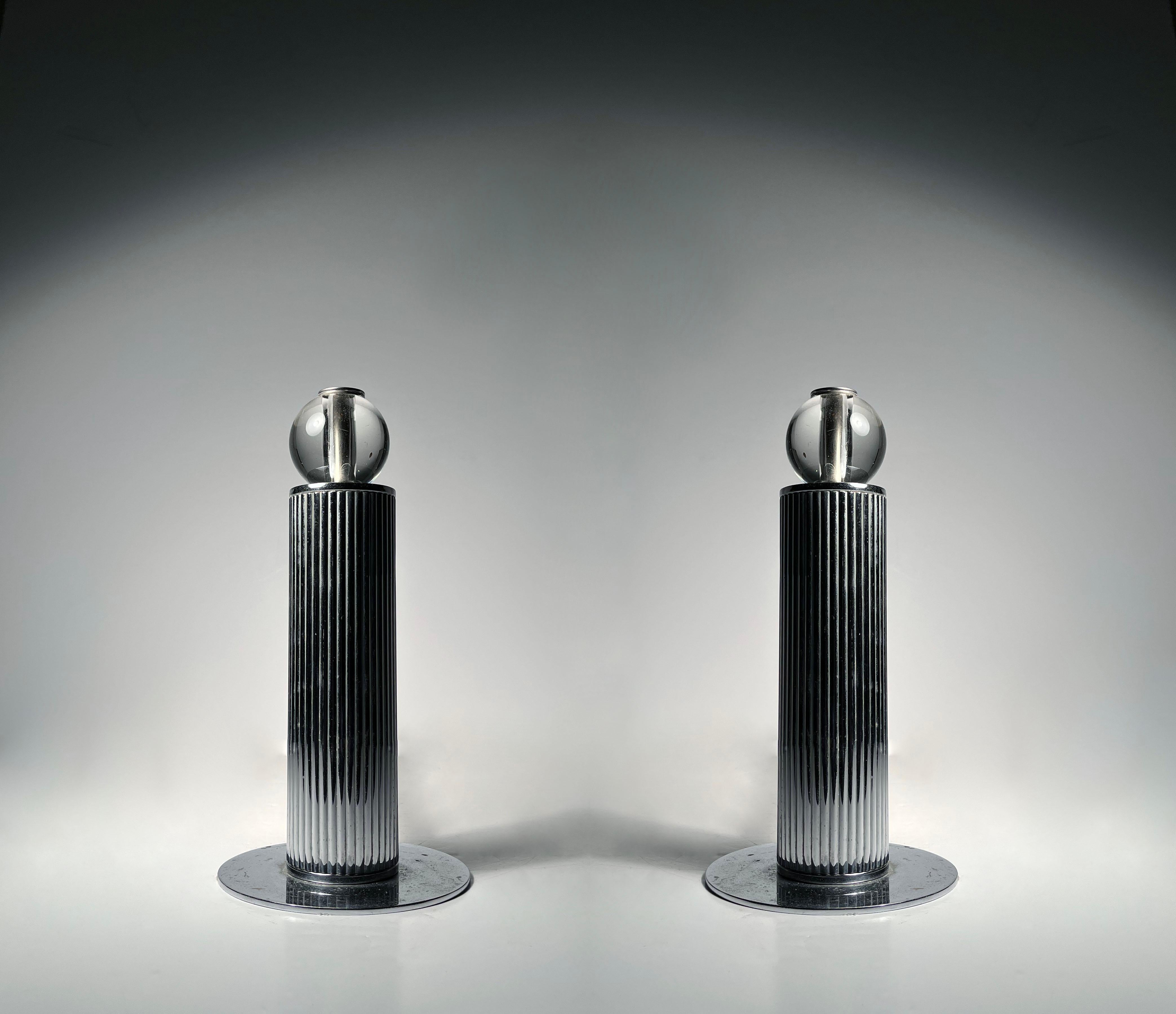 Paire de chenets modernistes Art déco pour gratte-ciel. Très probablement attribuable à l'un des concepteurs cités. Non marqué.  Sphère en verre avec pièces chromées. 