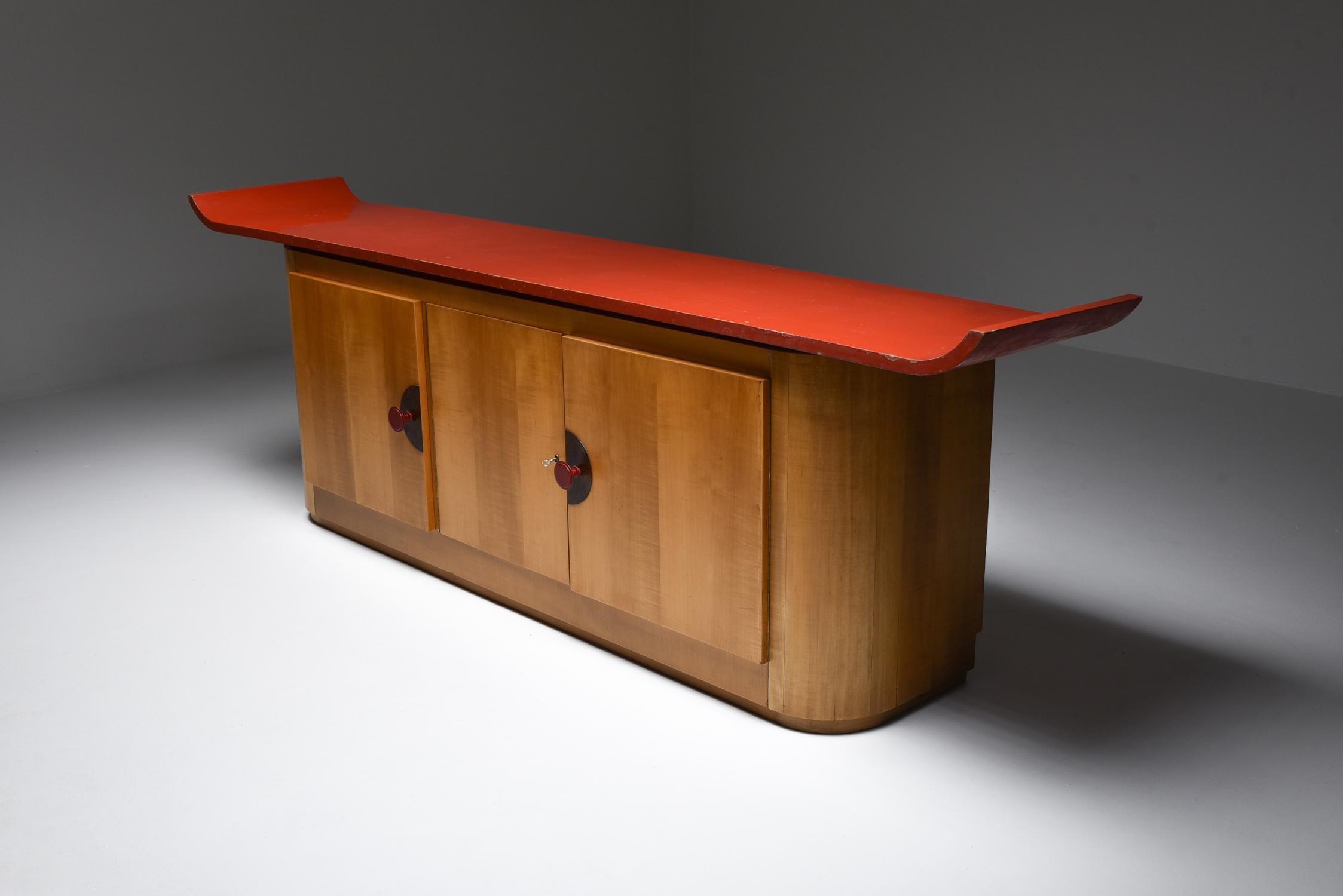 Modernist Art Deco credenza, France, circa 1930

Flamboyant piece in beech, red lacquered top and handles, palm wood details
Impressive and unusual storage piece in original condition from the early modernism, Art Deco era.
Too many interesting