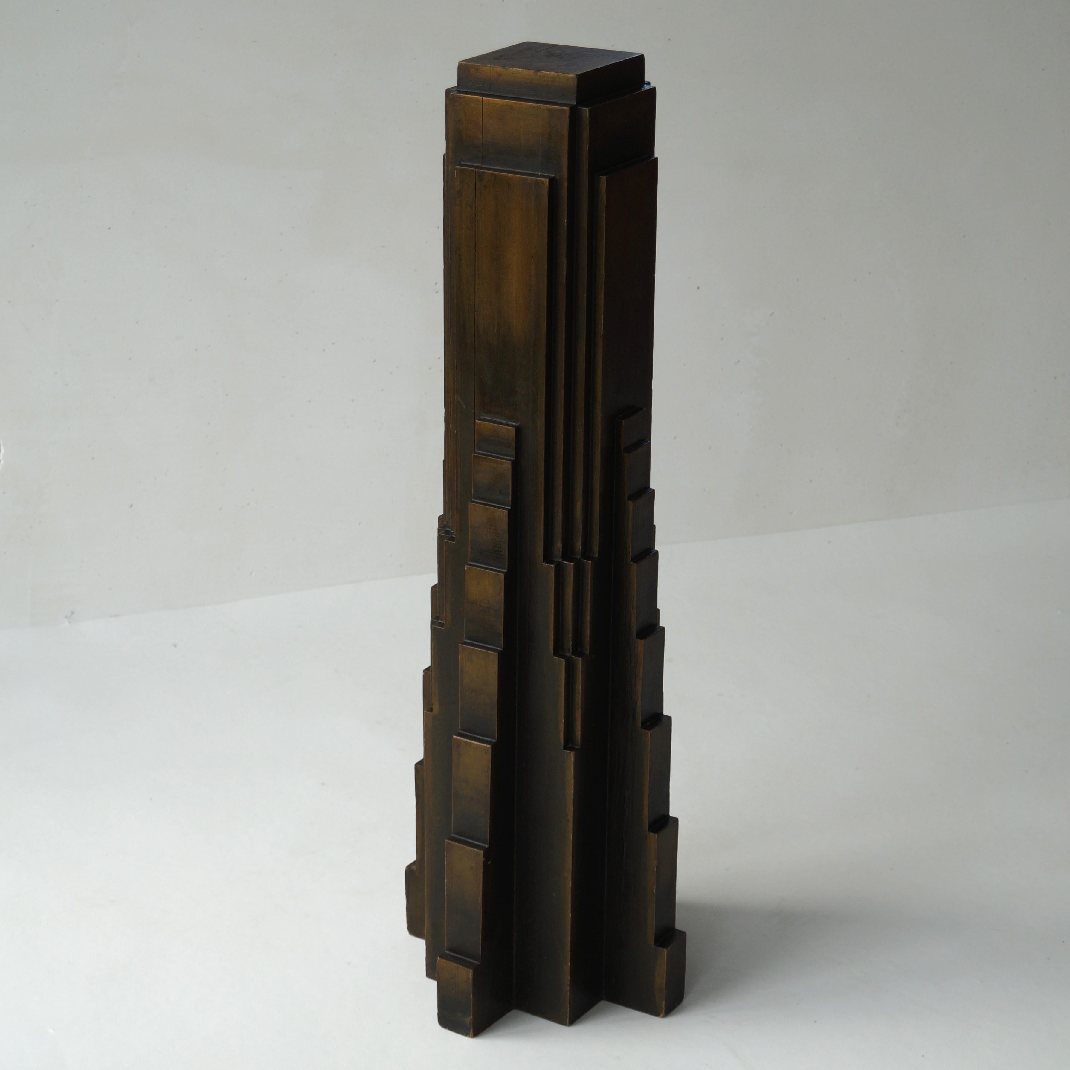 A tall and solid wooden antique art deco pedestal, column or plinth, dating from around 1930 and most probably made in Belgium.
The piece has an impressive sculptural design with modernist lines in the shape of a skyscraper, tapering towards the