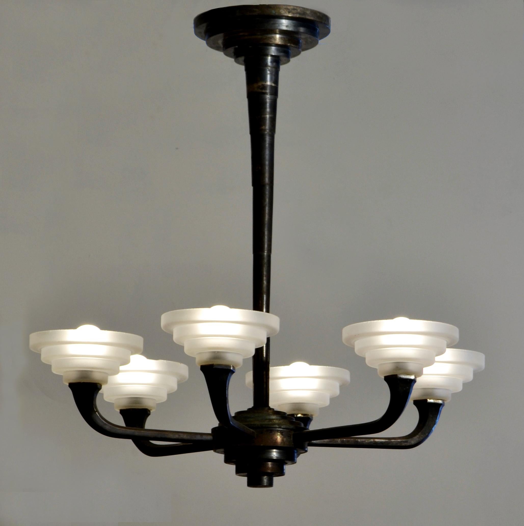 Geometric Modernist French uplighter chandelier has six arms, the frame is dark patinated silver plated in a stepped design. The 6 frosted glass shades follow the staggered design of the frame. This 1920s, French chandelier is a perfect example of