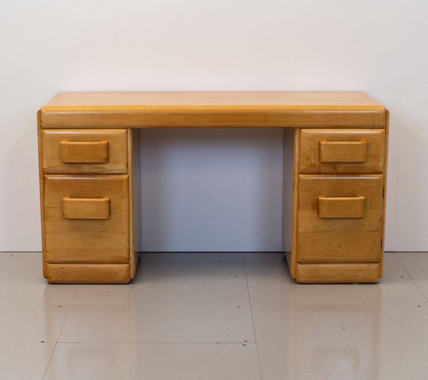 American Art Deco – Modernist solid maple dressing table by Russel Wright for conant ball. It has five drawers two of which are hidden behind a cupboard door and a matching maple stool reupholstered in a 100% blue wool fabric by Abraham Moon. This