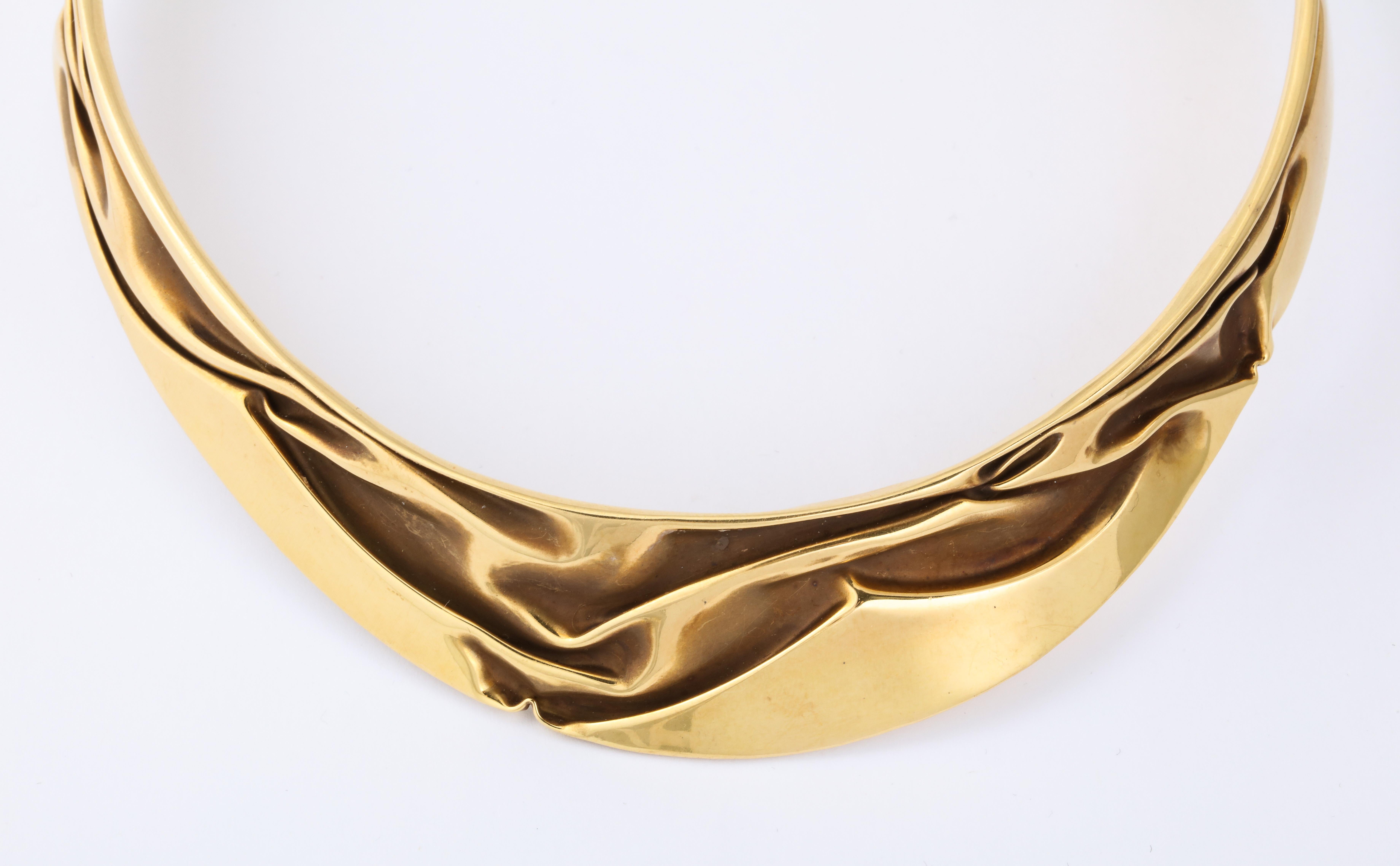 A wonderful Modernist Articulated Gold Collar with raised wave designs This 18 k gold necklace uses folds of the solid gold to create a draped appearance.  Signed HM.
Note that this is open and will fit any neck.