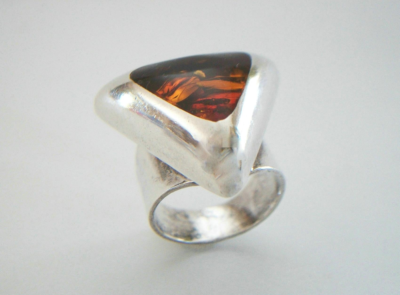 Modernist Baltic amber and sterling silver ring - bold style - wide band - flush mount amber setting (trilliant cut cabochon with domed and polished finish - approx. 3.8 carats - 15 mm. Wide x 15 mm. High) - hallmarks to the back of the band -