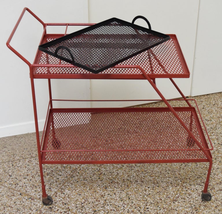 Two-tier rolling cart with bottle rack and removable tray in the style of Mathieu Matégot. Recently repainted in brick red and black.