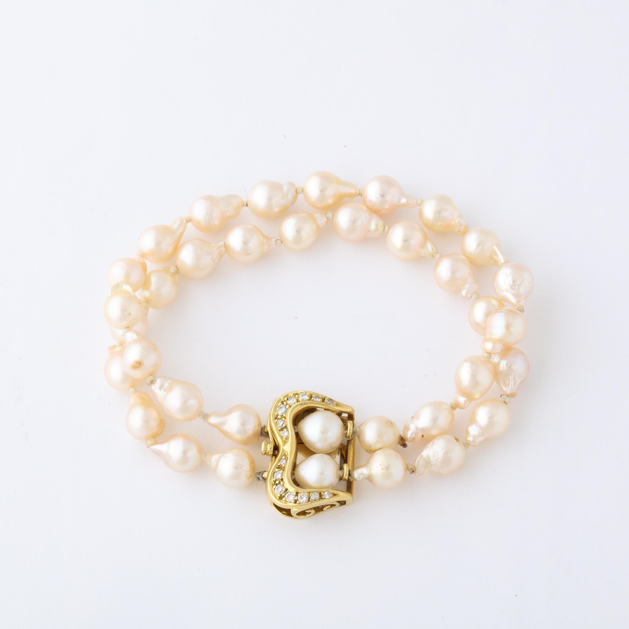 This Modernist double strand pearl bracelet is set with 34 water pearls and fitted with a 18k yellow gold buckle style clasp set with 14 single cut diamonds and 2 water pearls . This bracelet has an organic, modernist and yet classic feel . A very