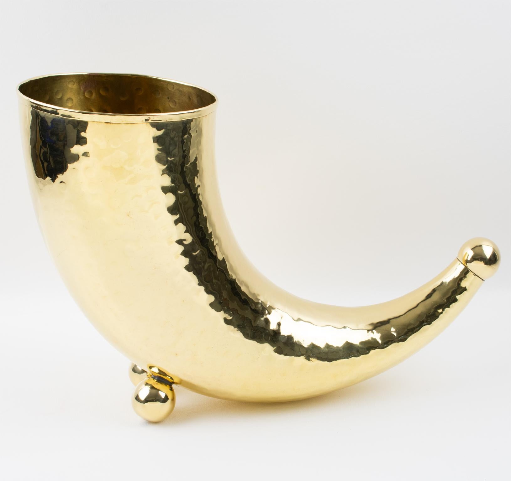 Questo elegante vaso o refrigeratore per vino in ottone modernista presenta una forma versatile e ultra-chic con uno stravagante e minimalista corno dell'abbondanza, completo di piedini in perline e di una finitura metallica lucida e leggermente