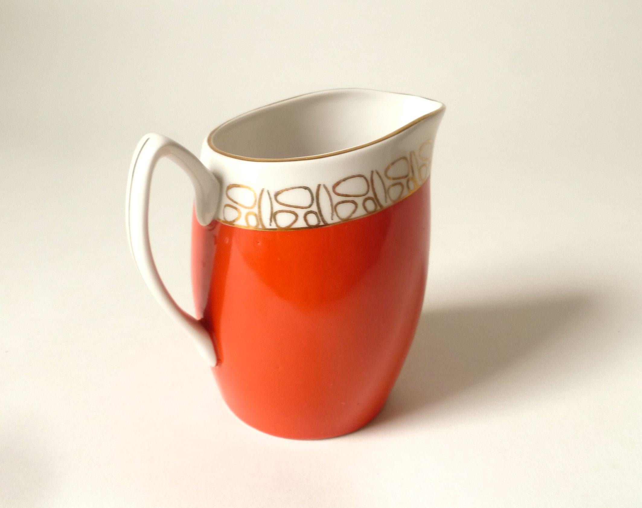 Polish porcelain creamer with gold line detailing and stylized handle. Bauhaus design in typical orange color. Made in Chodziez/Cmielow porcelain factory.

Very good vintage condition without chips/cracks. Very, very light wear.