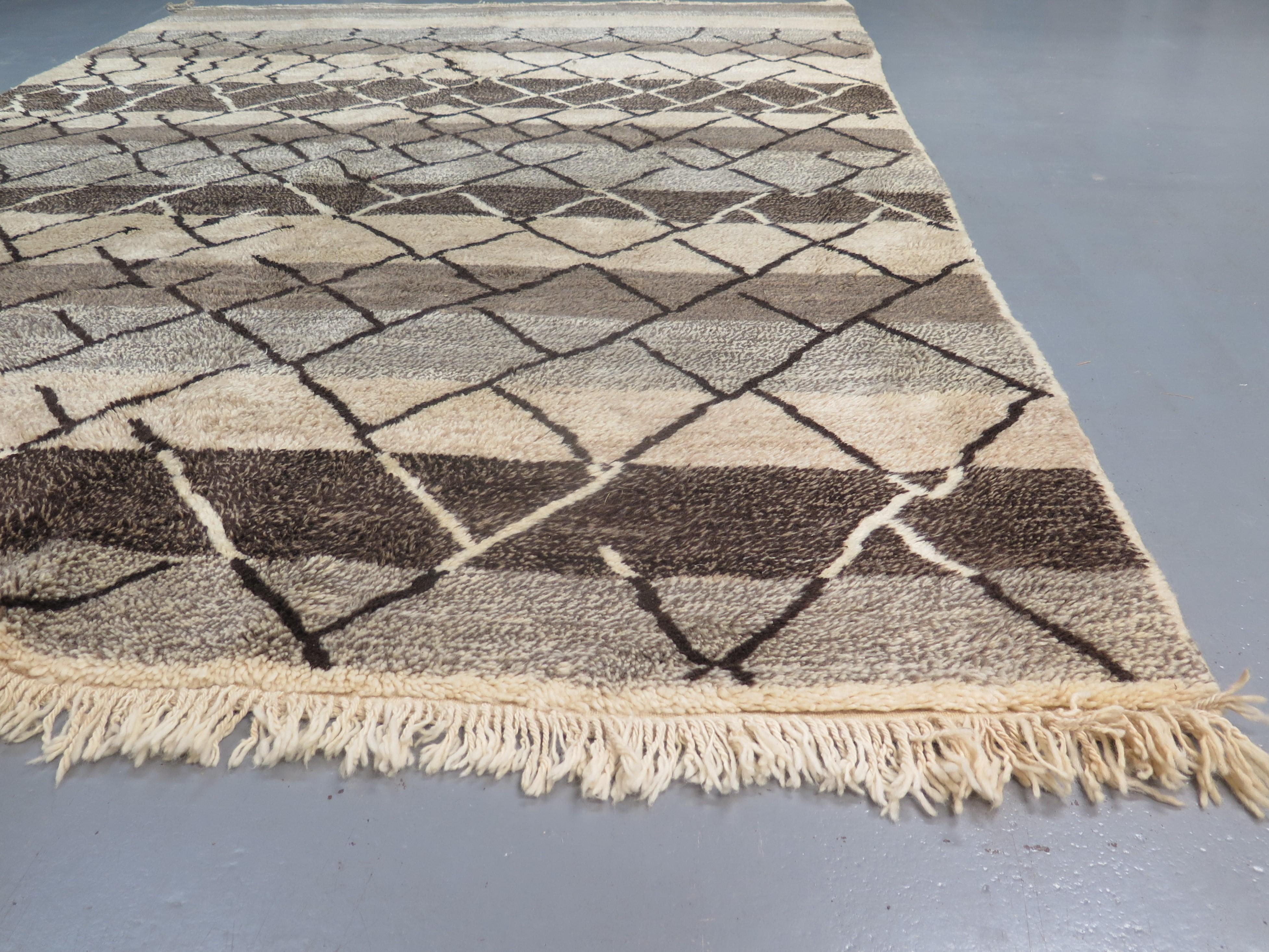 Ein zeitgenössischer marokkanischer Teppich, handgeknüpft aus hochwertiger Wolle, inspiriert von den begehrten Beni Ourain-Knüpfungen aus der Jahrhundertmitte, die von Designern wie Alvar Aalto und Le Corbusier bekannt gemacht wurden.

Der