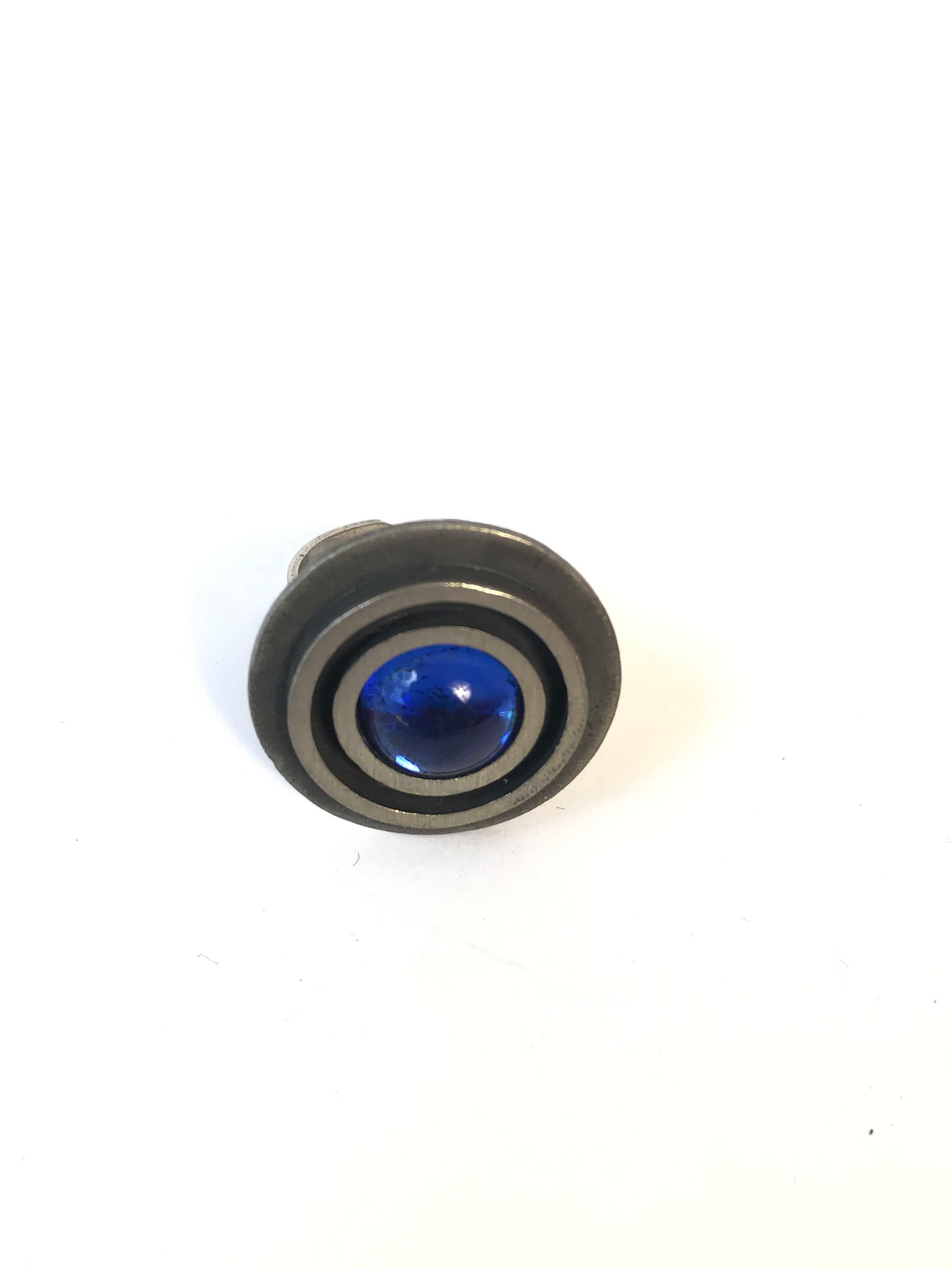 Modernist Bent Larsen adjustable size ring made in Denmark. Blue glass cabochon with silver plated pewter. Condition: Excellent. 

 