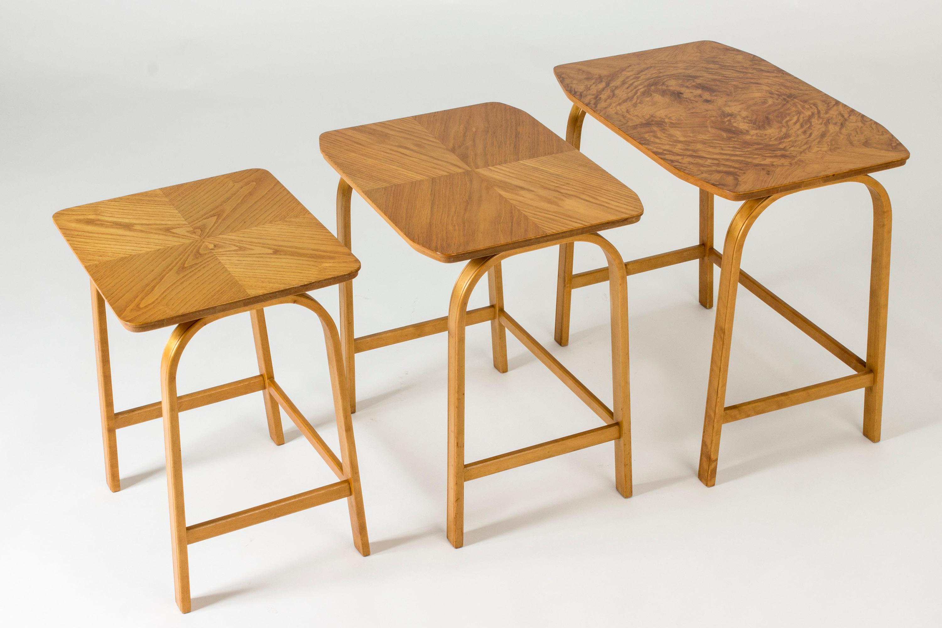 Nesting table with three tables in different sizes by Axel Larsson. Beautiful, clean silhouette and a warm birch color. Each table top has a different kind of look, with root veneer on the largest and decoratively laid wood on the smaller ones.