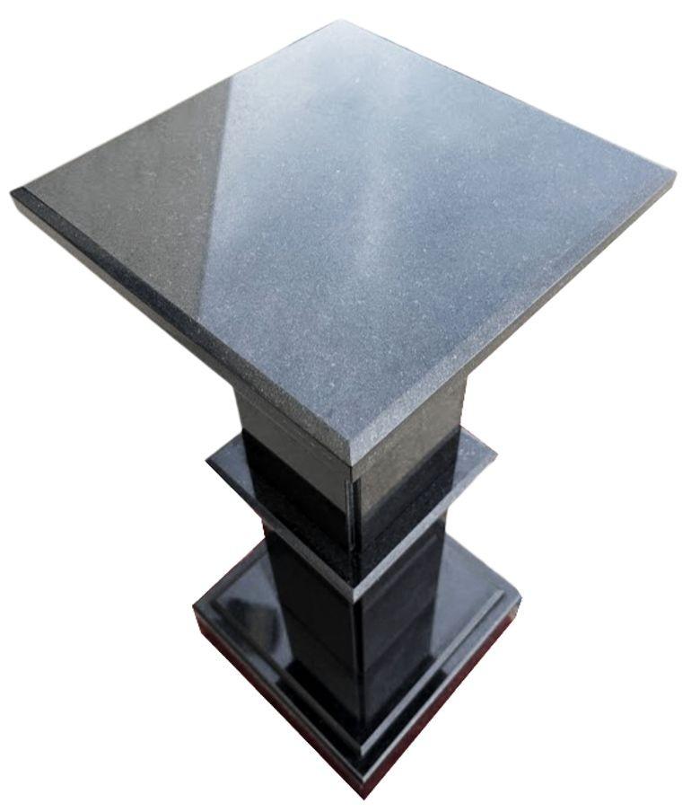Un pedestal de granito negro es un soporte liso y elegante elaborado con piedra de granito negro pulido. Su superficie lisa y reflectante resalta la belleza natural del granito, mostrando sutiles vetas y profundidad. Con un diseño robusto y