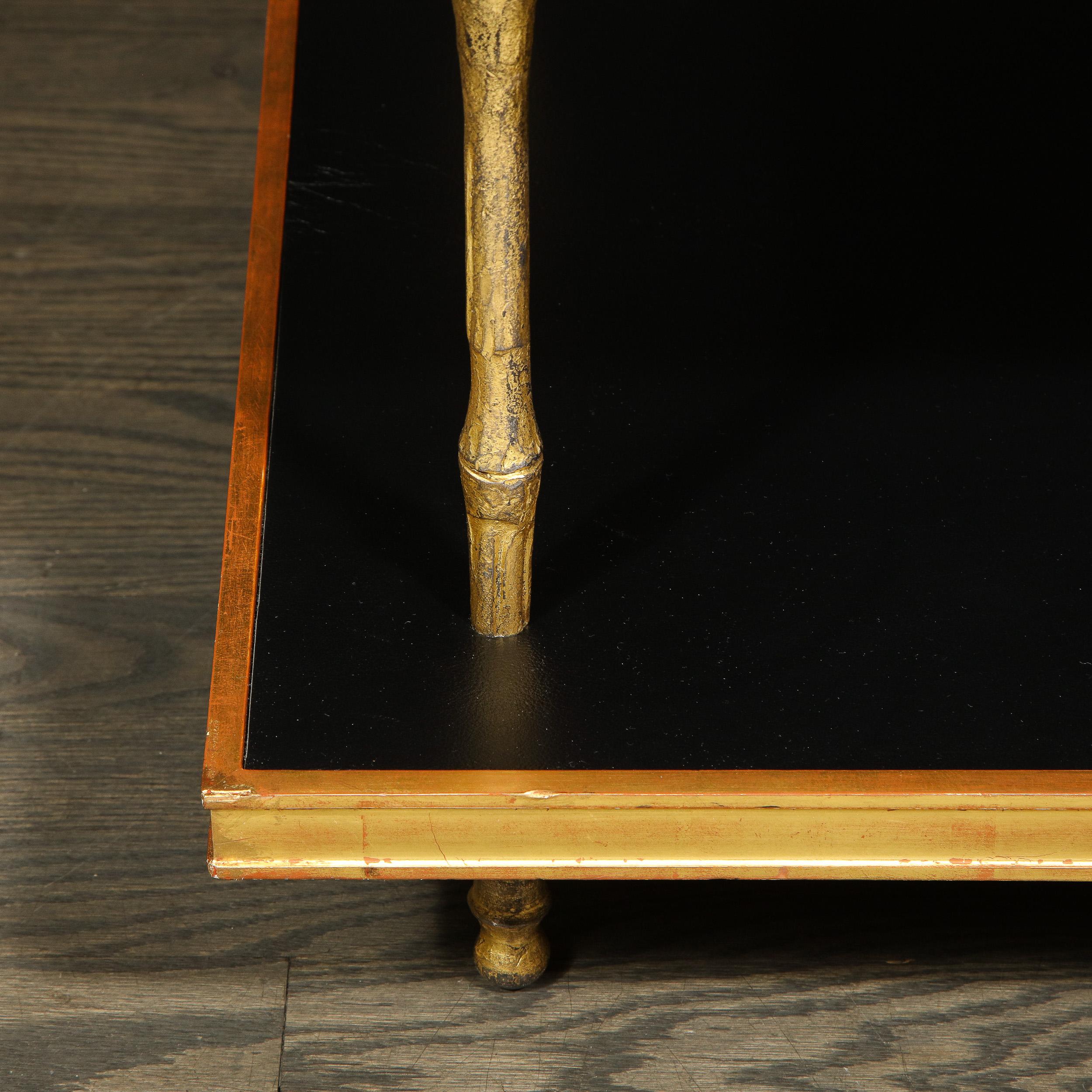 This elegant modernist two-tier cocktail table was realized in the United States by the esteemed atelier of Carole Gratale. The piece offers a rectangular body with a top and bottom tier circumscribed in giltwood with luxe black leather interiors.