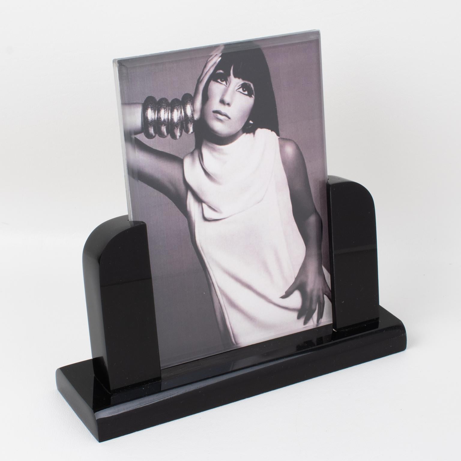 This beautiful Italian 1980s modernist Lucite picture photo frame features a thick licorice black Lucite base with beveling topped with carved pole holders. Two sheets of acrylic hold the photography in position. There is no visible maker's