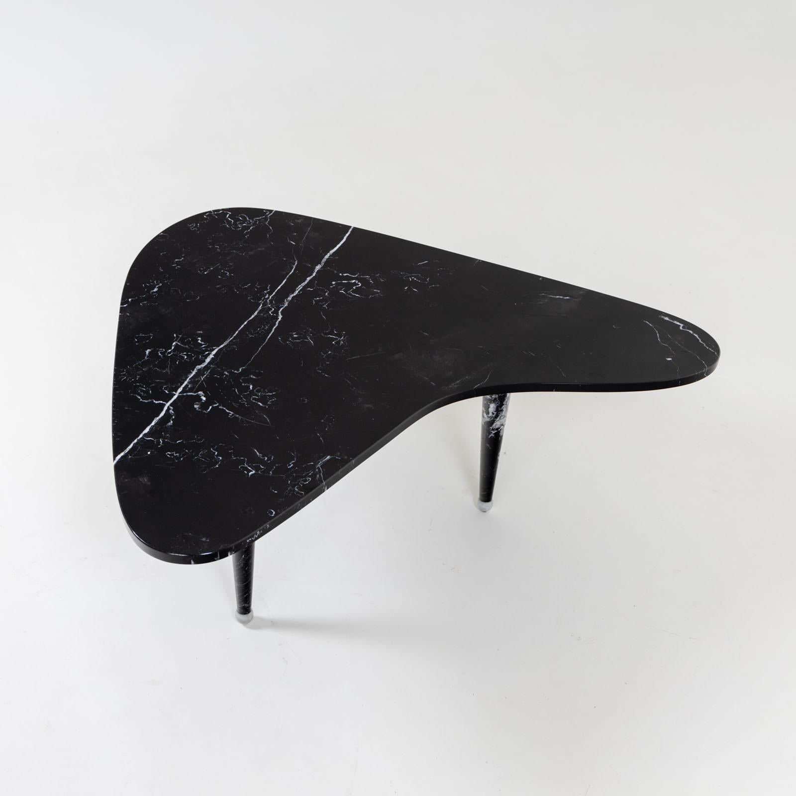 Italian coffee table with a boomerang-shaped top made of black marble with white veins.
The table stands on three conical legs, which are also made of black marble.