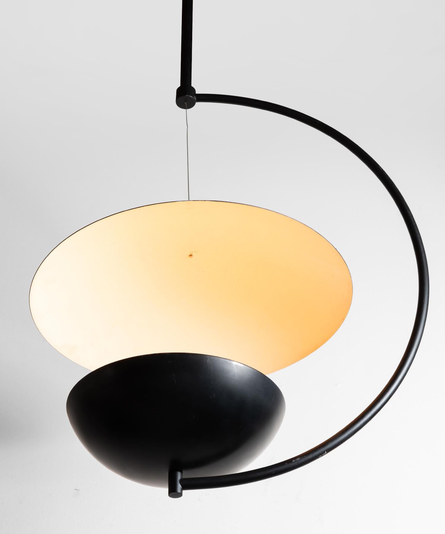 Crescent shaped modern pendant with hanging reflector disc.

 