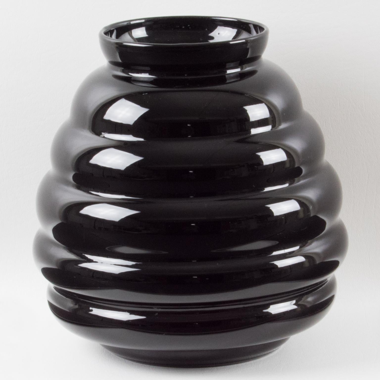 Questo splendido vaso in vetro opalino nero è stato realizzato a mano in Belgio intorno al 1950. Il design massiccio e arrotondato vanta una forma a gadroon. Il pezzo è stato contrassegnato sul lato inferiore con la scritta 