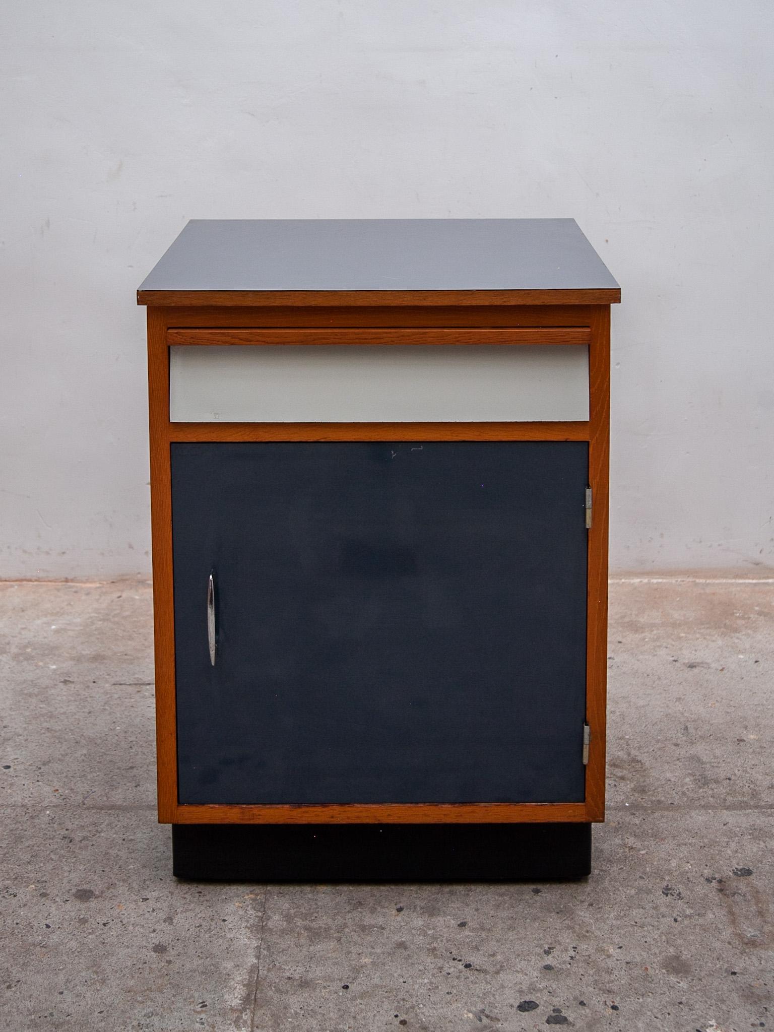 Seltenes kleines industrielles Sideboard mit einer Tür aus blauem Schichtstoff, einer Schublade aus weißem Schichtstoff und einer grauen Schichtstoffplatte. Die Konstruktion des Sideboards ist aus massiver Buche, entworfen von Tubax, Belgien 1958.