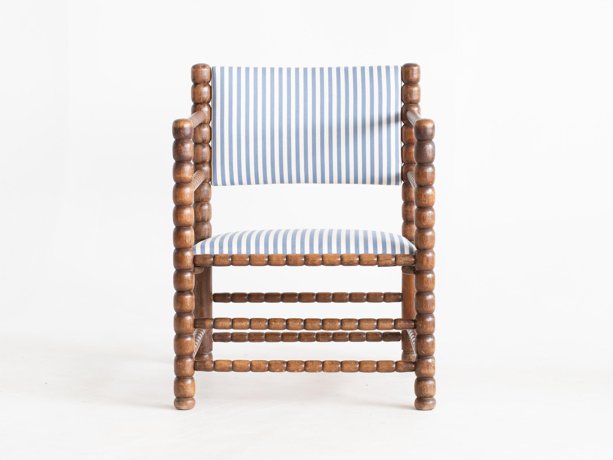 A bobbin-turned stained beech armchair with upholstered seat and backrest. French, c. 1930. 

Stock ref. #2157

Sturdy, patinated frame. Newly upholstered in a striped cotton ticking. 

78.5 x 61 x 63 cm (30.9 x 24.0 x 24.8 