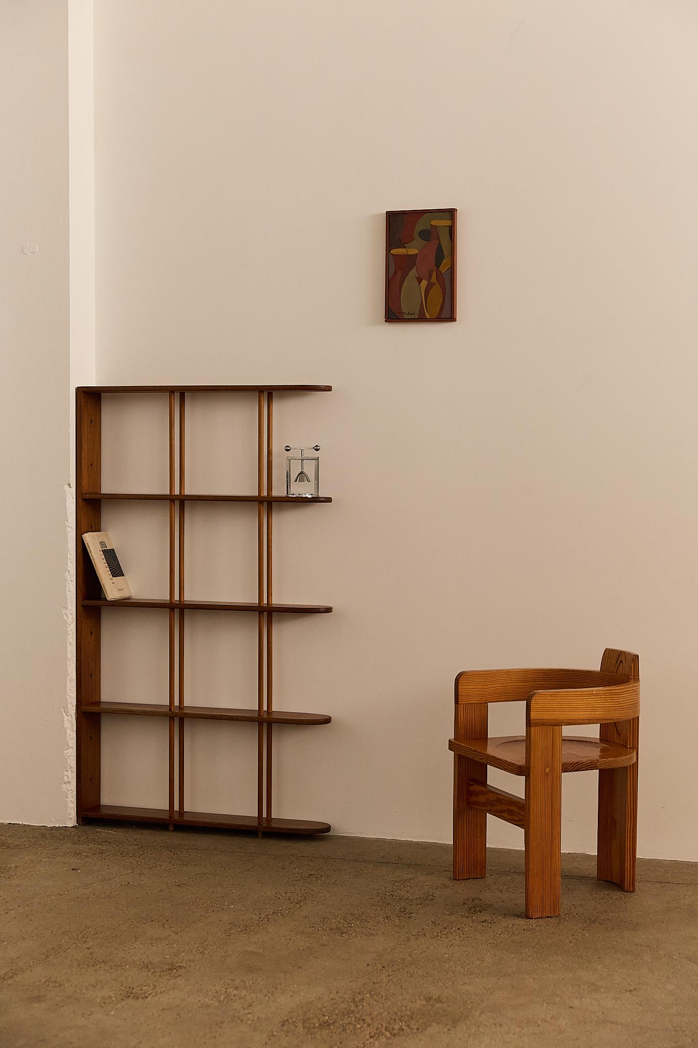A refined freestanding wall shelf from the 1940s, crafted in oak wood with slender vertical supports. The design features five evenly spaced shelves, each accented by elegant wooden rods that lend structure and visual rhythm. Minimal yet sculptural,