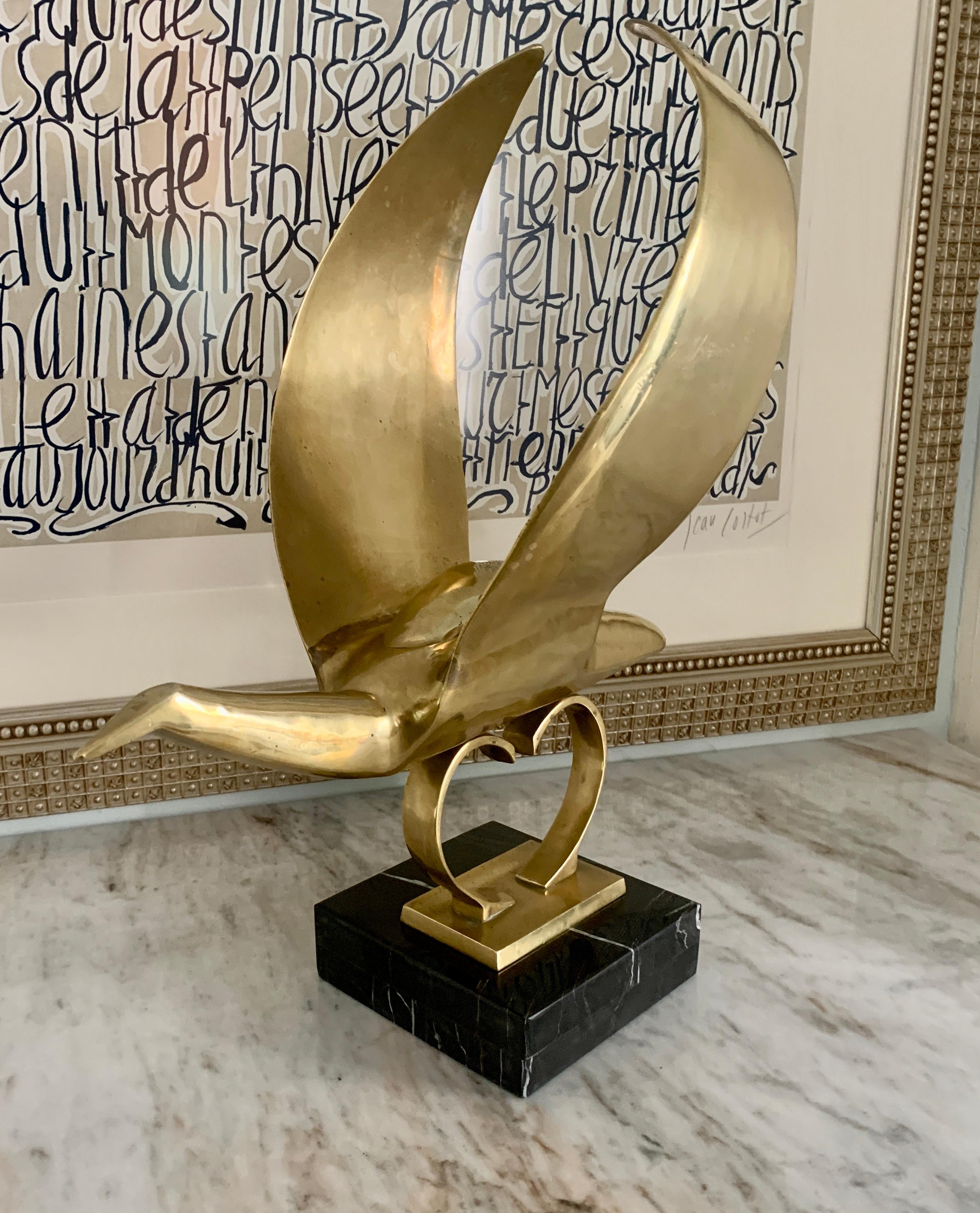 A large and impressive modern sculpture of a bird mounted on a custom marble base. We believe this piece to have been a hood ornament or architectural element. We have polished and mounted the bird on a black marble base. Impressive and of good