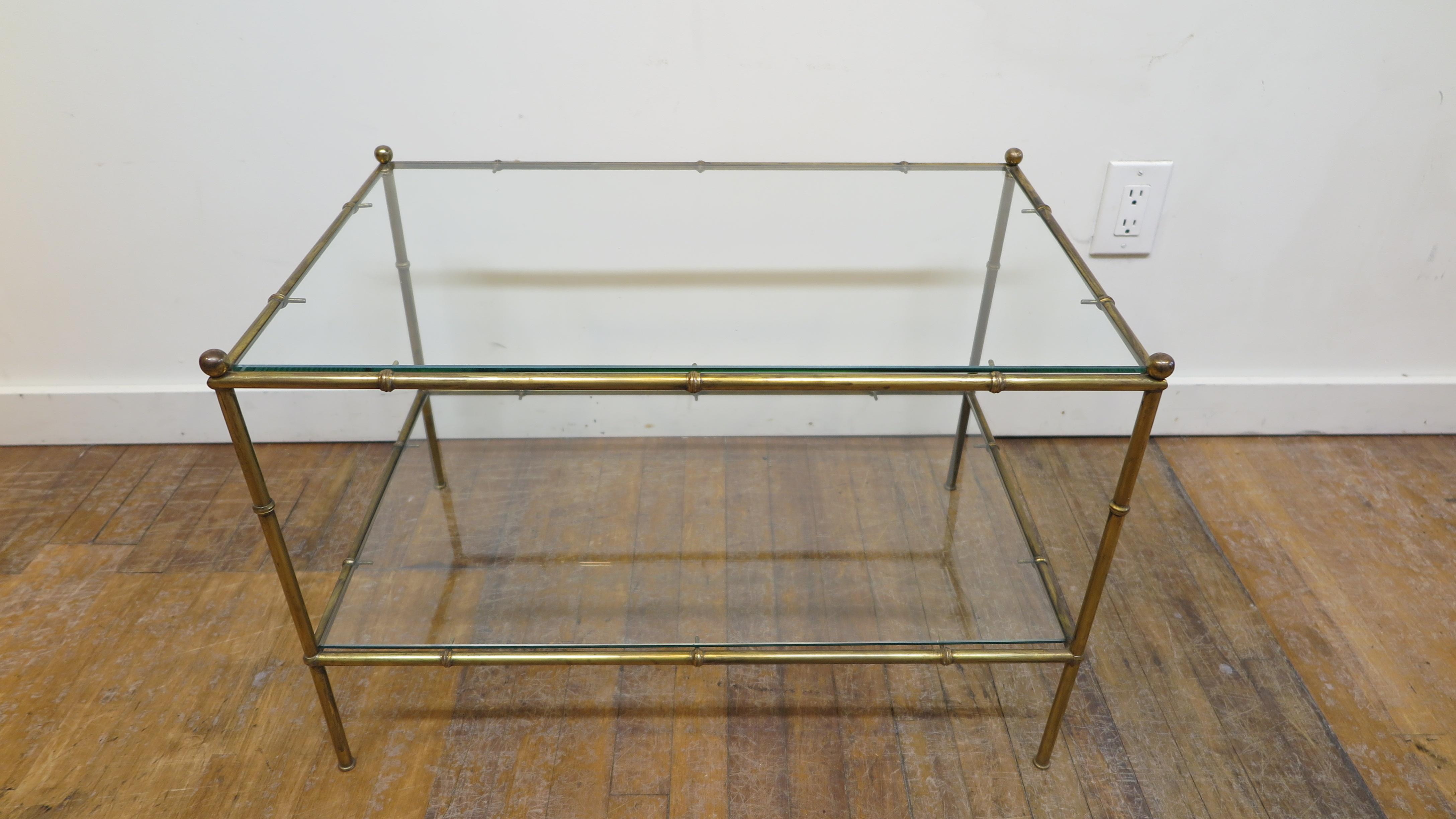 French midcentury brass and glass faux bamboo style cocktail table set of 3 pieces.
Wonderful set of three brass cocktail tables. Elegant modernist brass bamboo stylized table set. Each table having a lower shelf. Can be used as the set of three