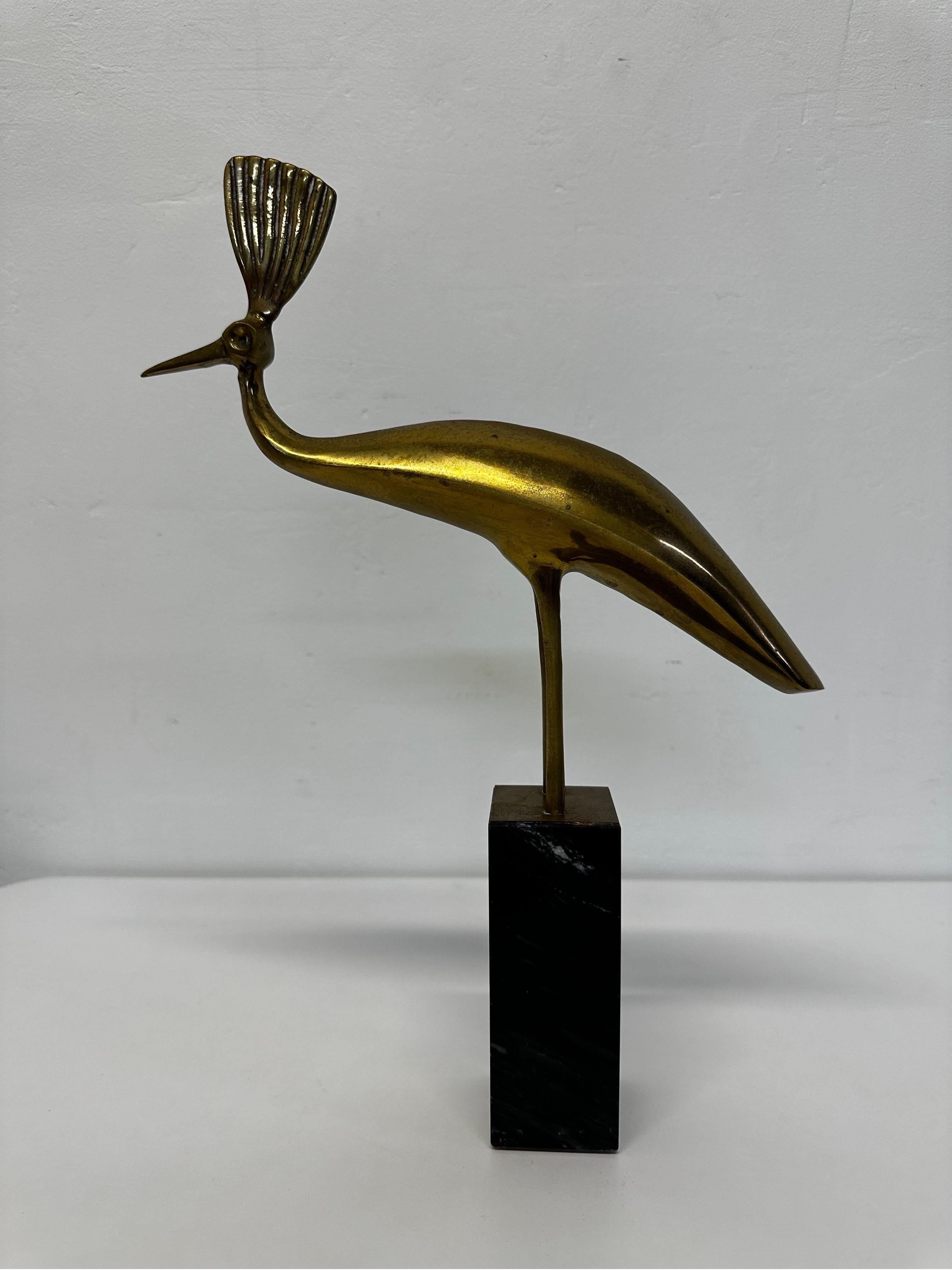 Mid-Century modernist patinated brass peacock sculpture on top of a black with white veining marble base circa 1970s.