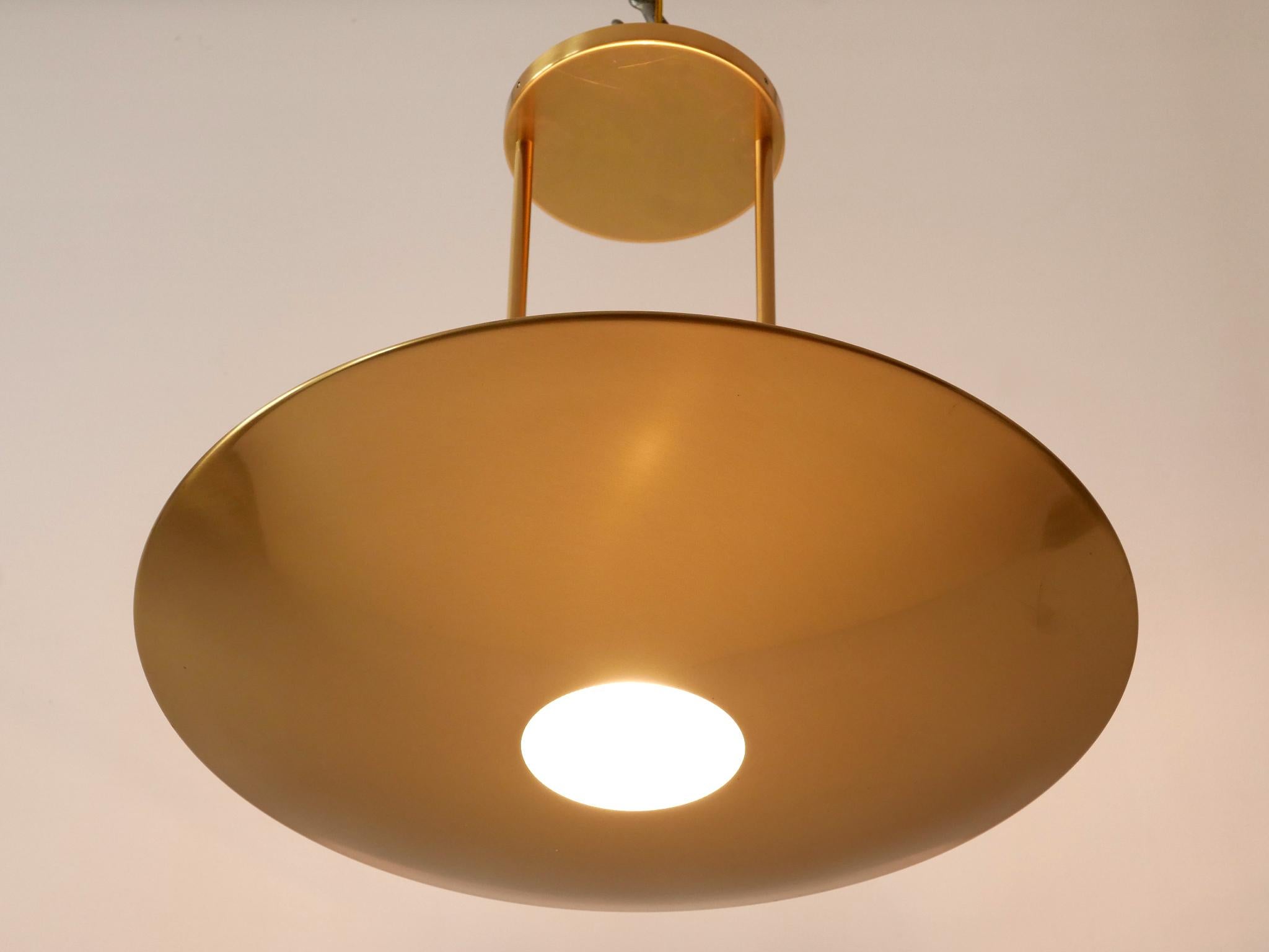 Elegant and minimalist brass pendant lamp / ceiling fixture. Designed & manufactured by Florian Schulz, Germany, 1980s.

Executed in polished brass and glass, the pendant lamp needs a halogen bulb R7, is wired and in working condition. It runs both
