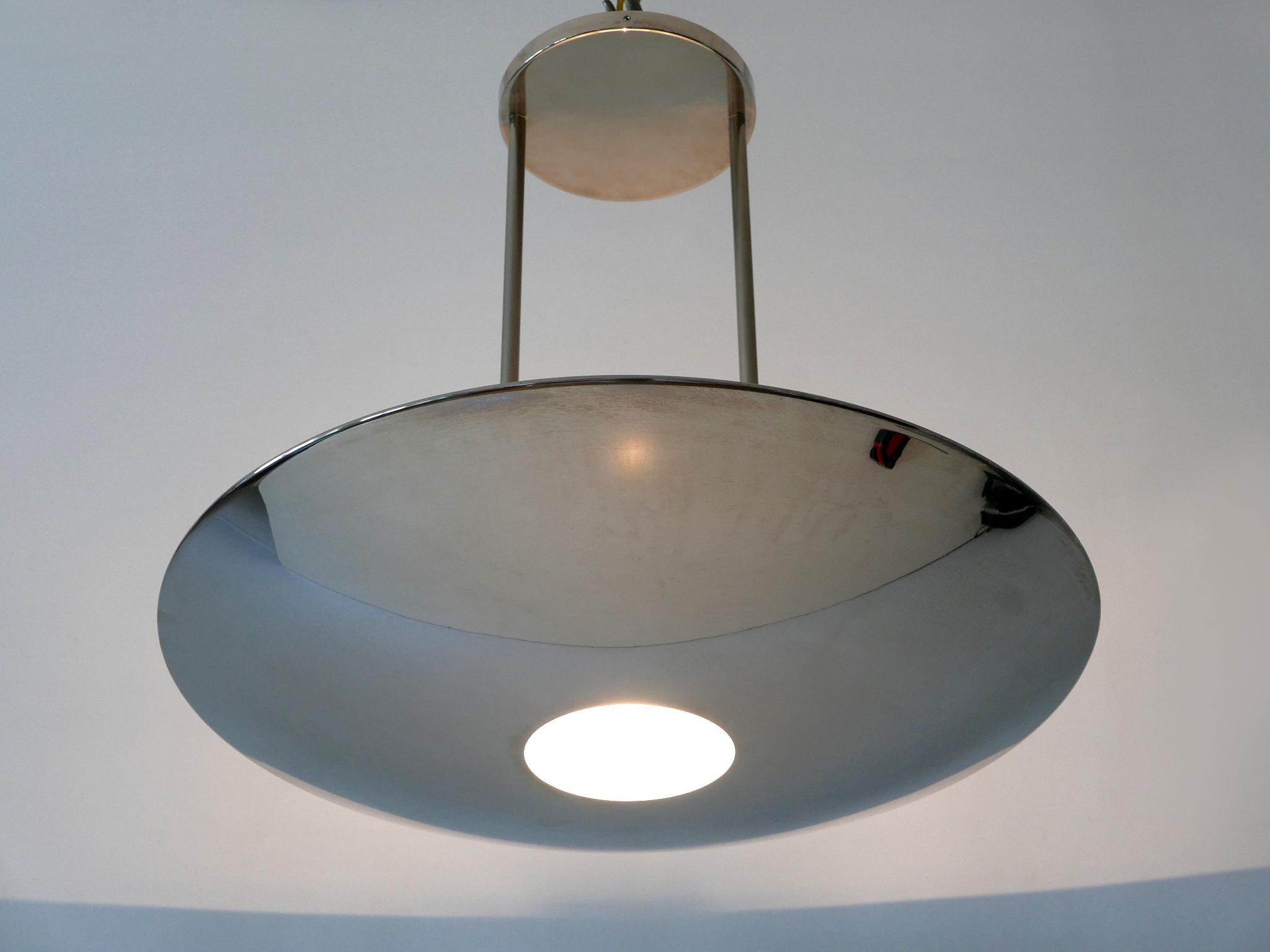 Elegant and minimalist nickel-plated brass pendant lamp / ceiling fixture with adjustable hanging height. Designed & manufactured by Florian Schulz, Germany, 1980s.

Executed in nickel-plated brass and glass, the pendant lamp needs a halogen bulb