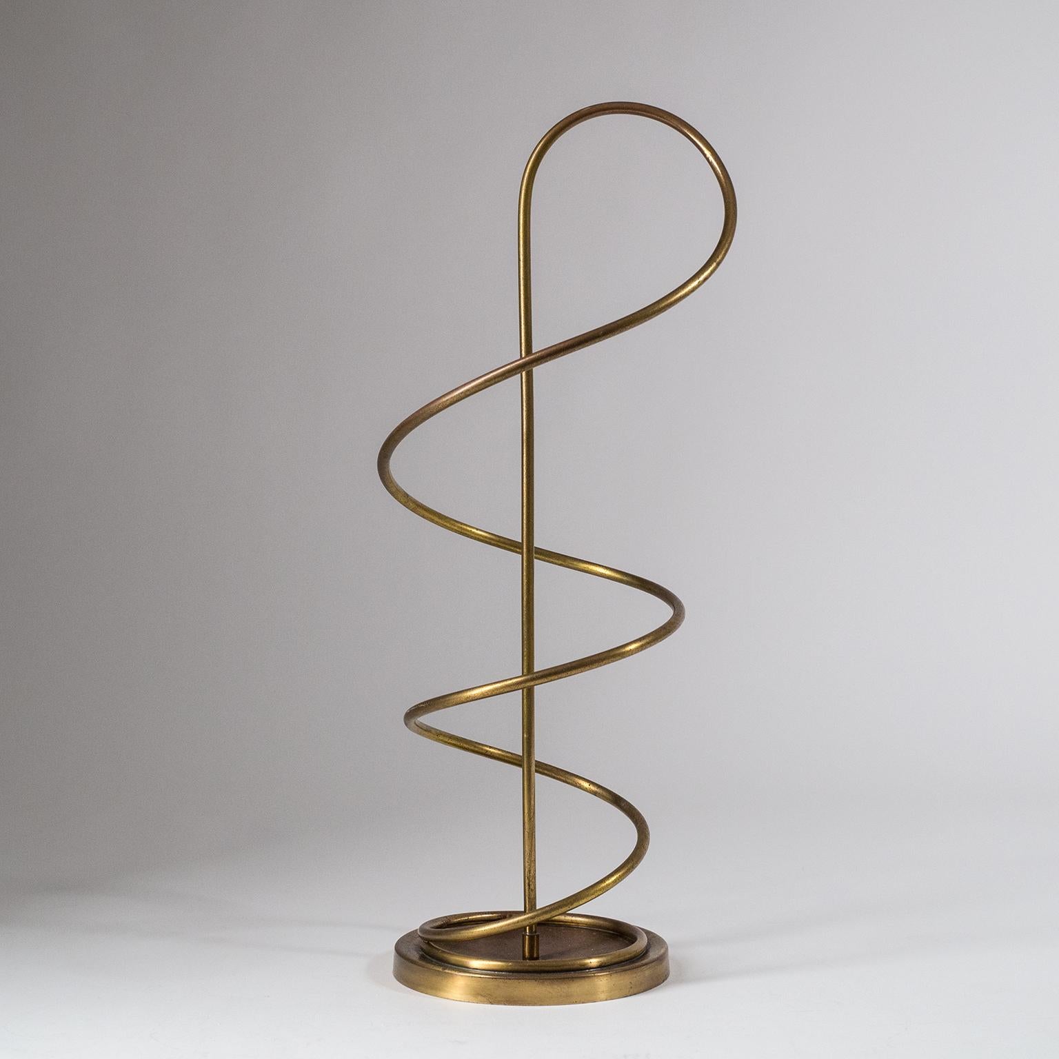 Rare modernist umbrella stand by Harald Buchrucker, circa 1950. A brilliant minimalist and sculptural design consisting of a weighted brass base and a single brass stem which 'sprouts' out of the center of the base and then spirals back down to