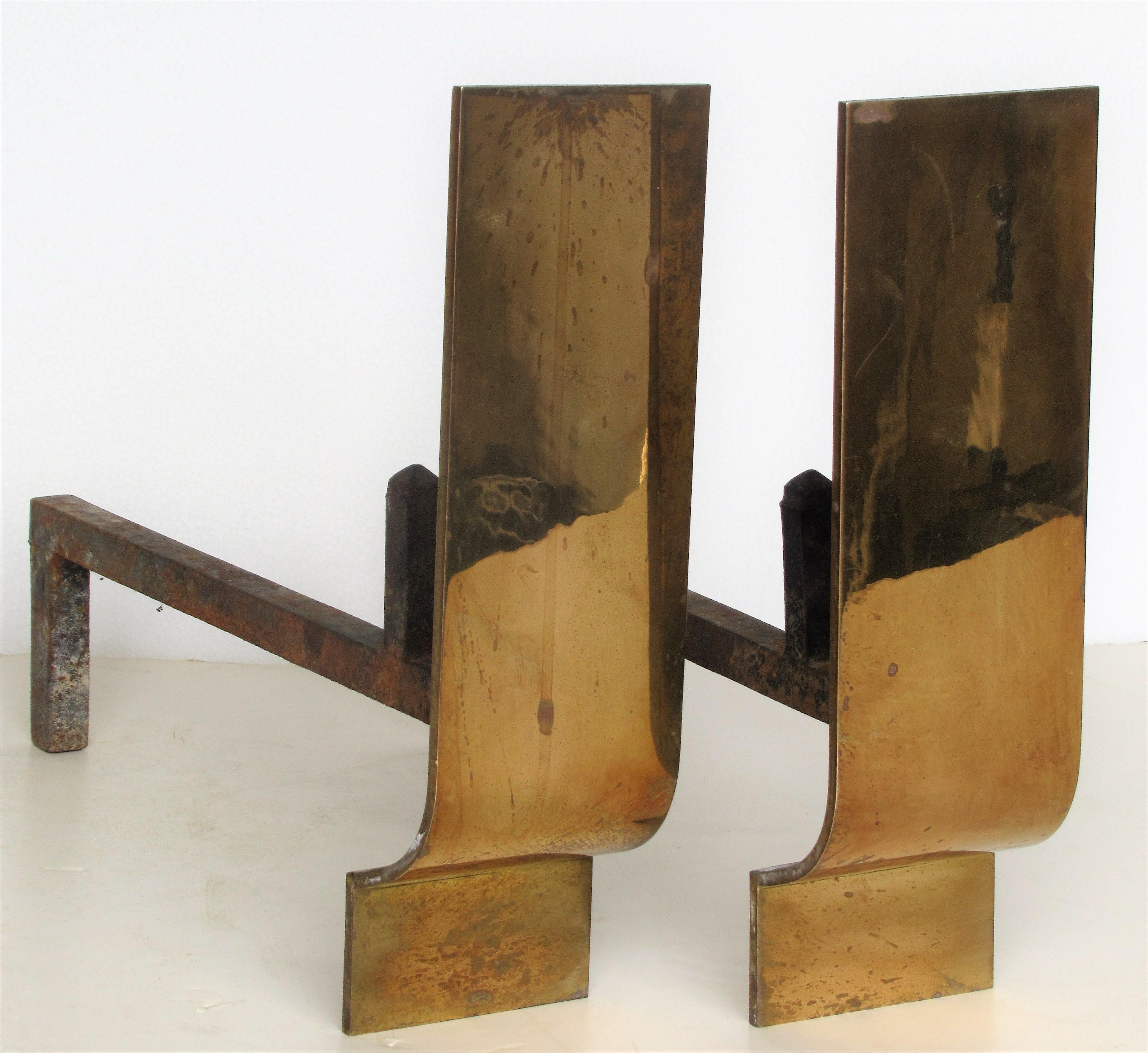 A pair of modernist bronze and iron andirons with a beautiful austere sculptural form, circa 1960-1970.