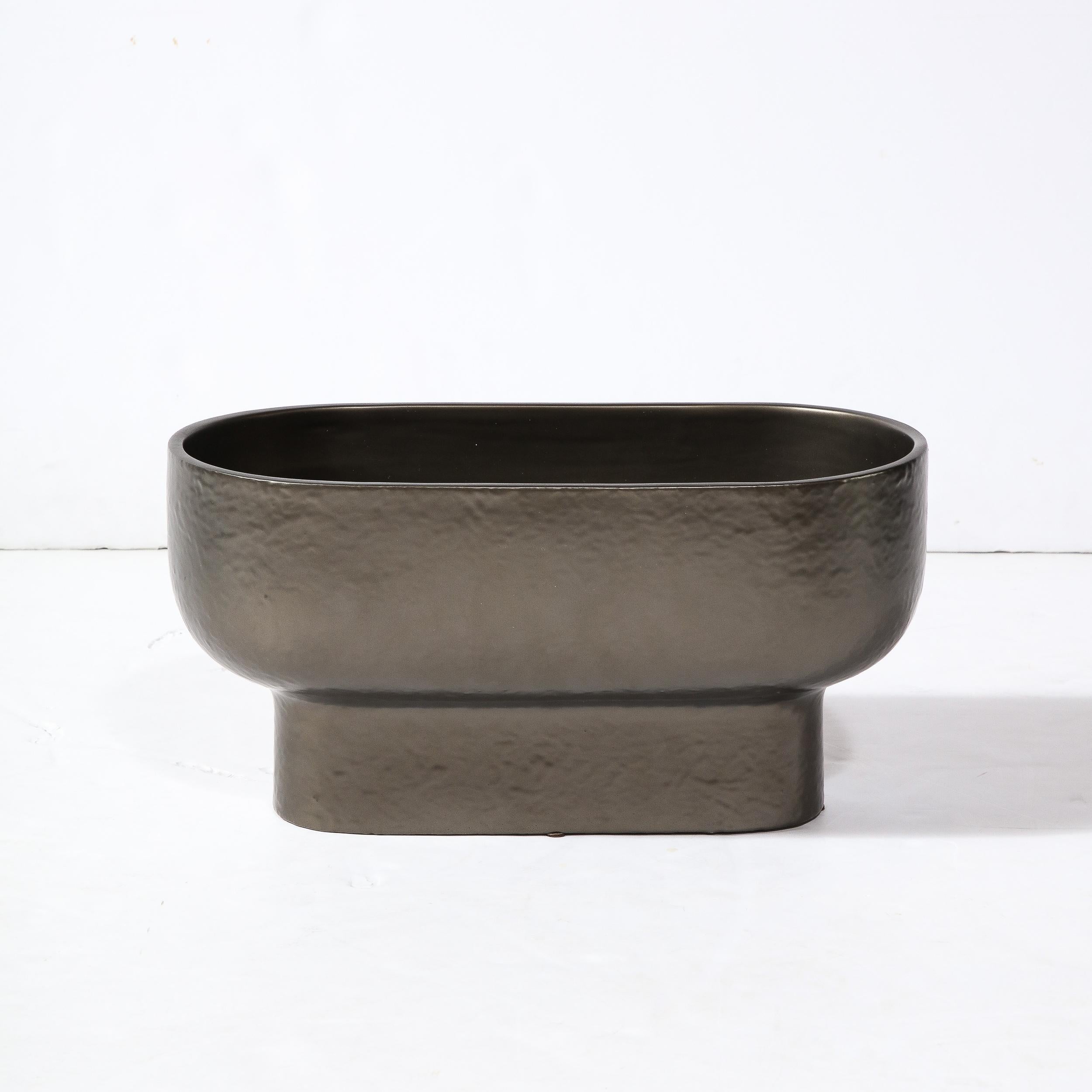 This sophisticated modernist orchid vase/ occasional bowl was realized in the United States during the latter half of hte 20th century. Realized in ceramic and finished with a bronze hued glaze (offering a subtle metallic sheen and texture), this