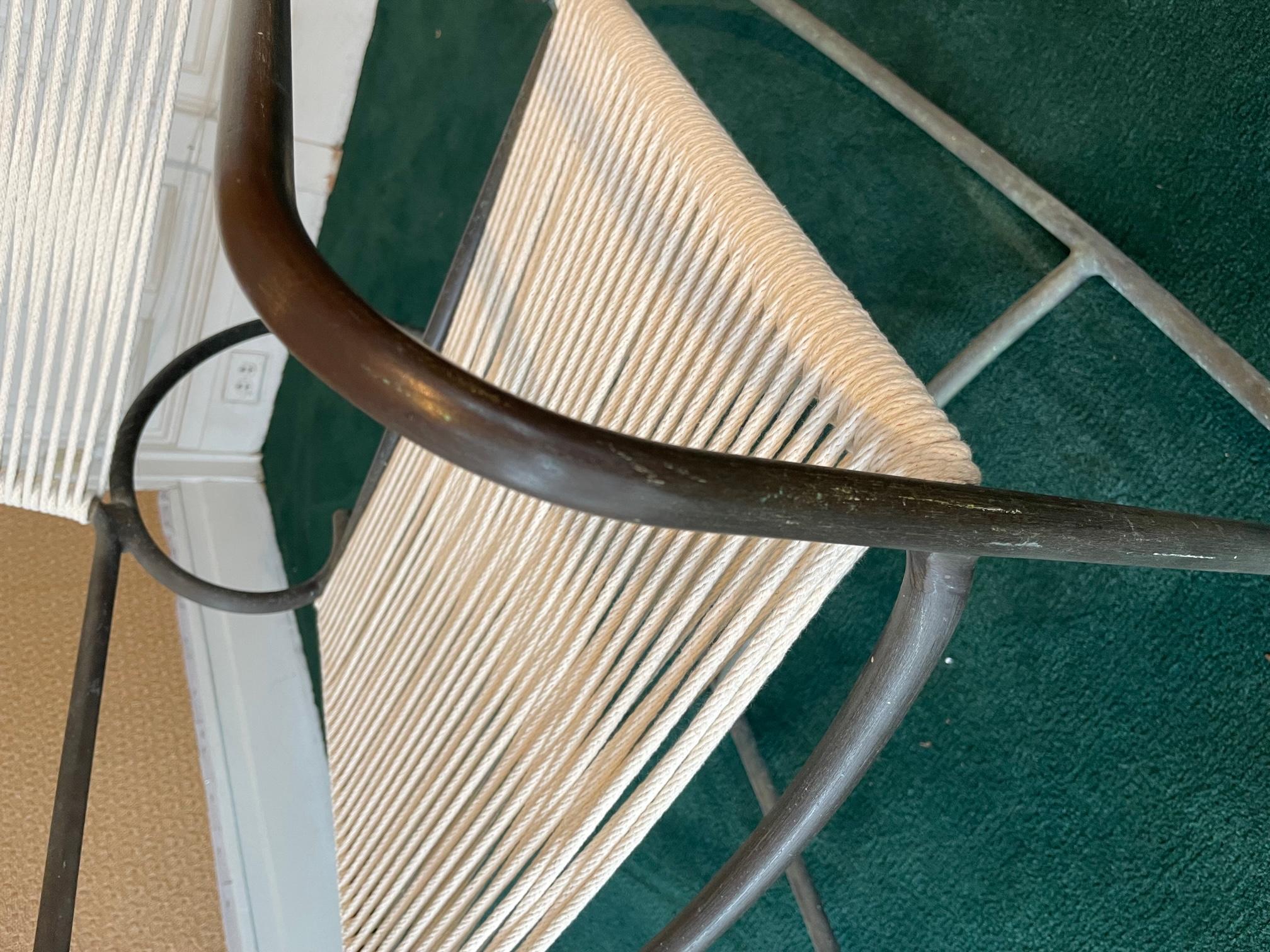 A bronze rocker designed by Walter Lamb for Brown Jordan Furniture, this bronze modernist piece has a powerful simplicity of line that makes it an iconic design. The original cotton yacht cording on the seat and back has been replaced and is what