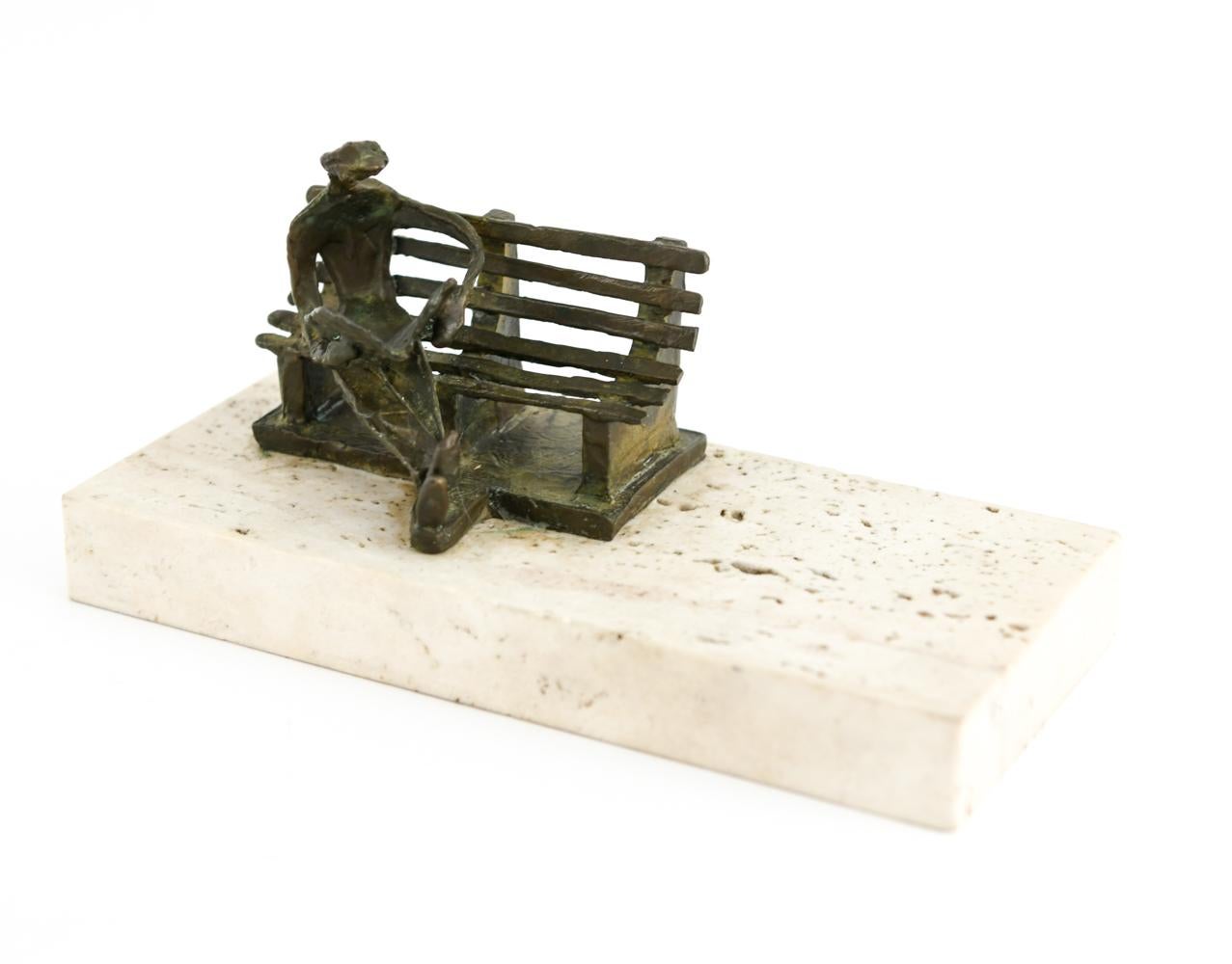 Reader on a bench. Mounted on travertine base.