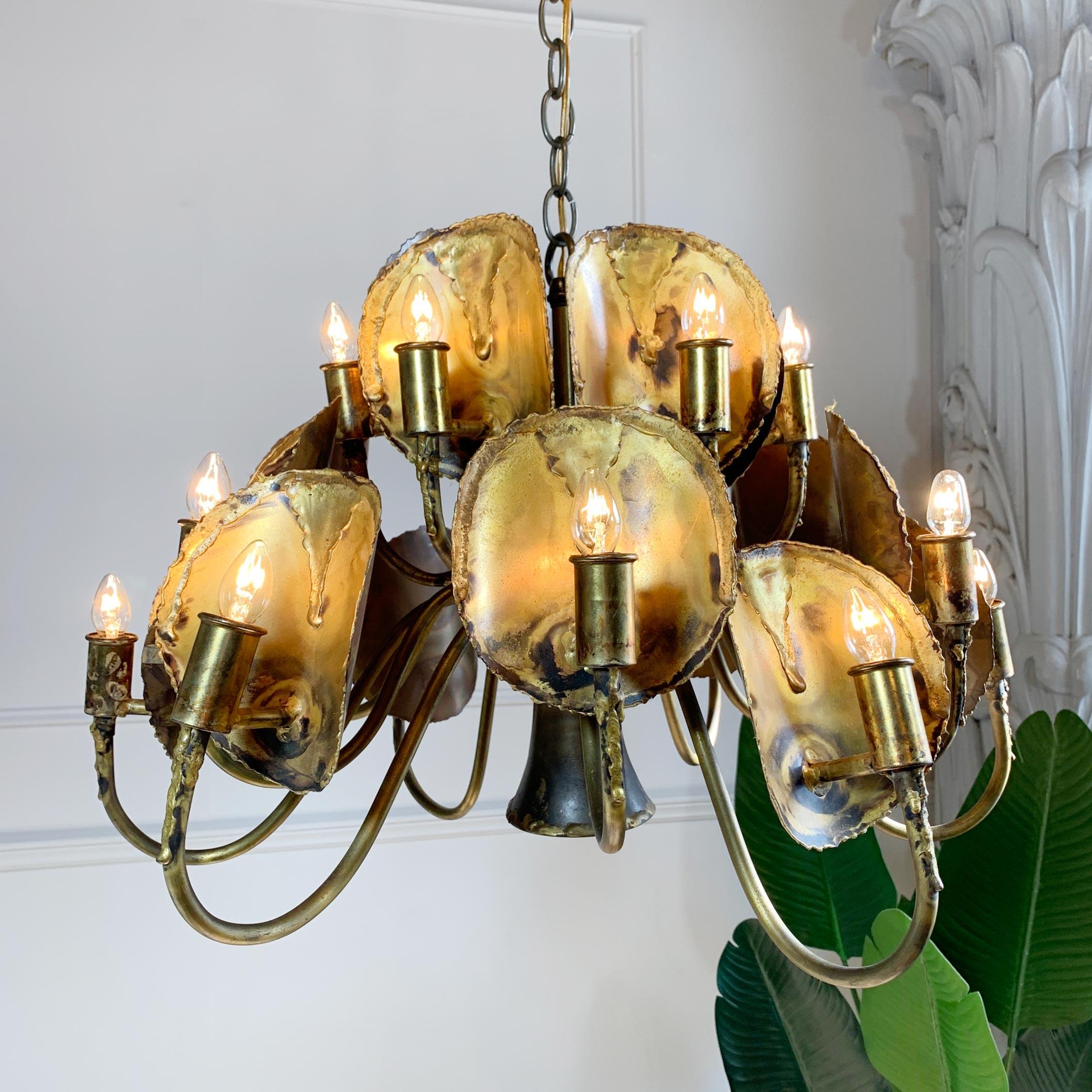 LA based designer and sculptor Tom Greene hand crafted this brutalist chandelier for 'Feldman Lighting Company' in the late 1960s/1970s
The design features staggered tiers of torch cut patinated brass disks, these are arranged cleverly so the light