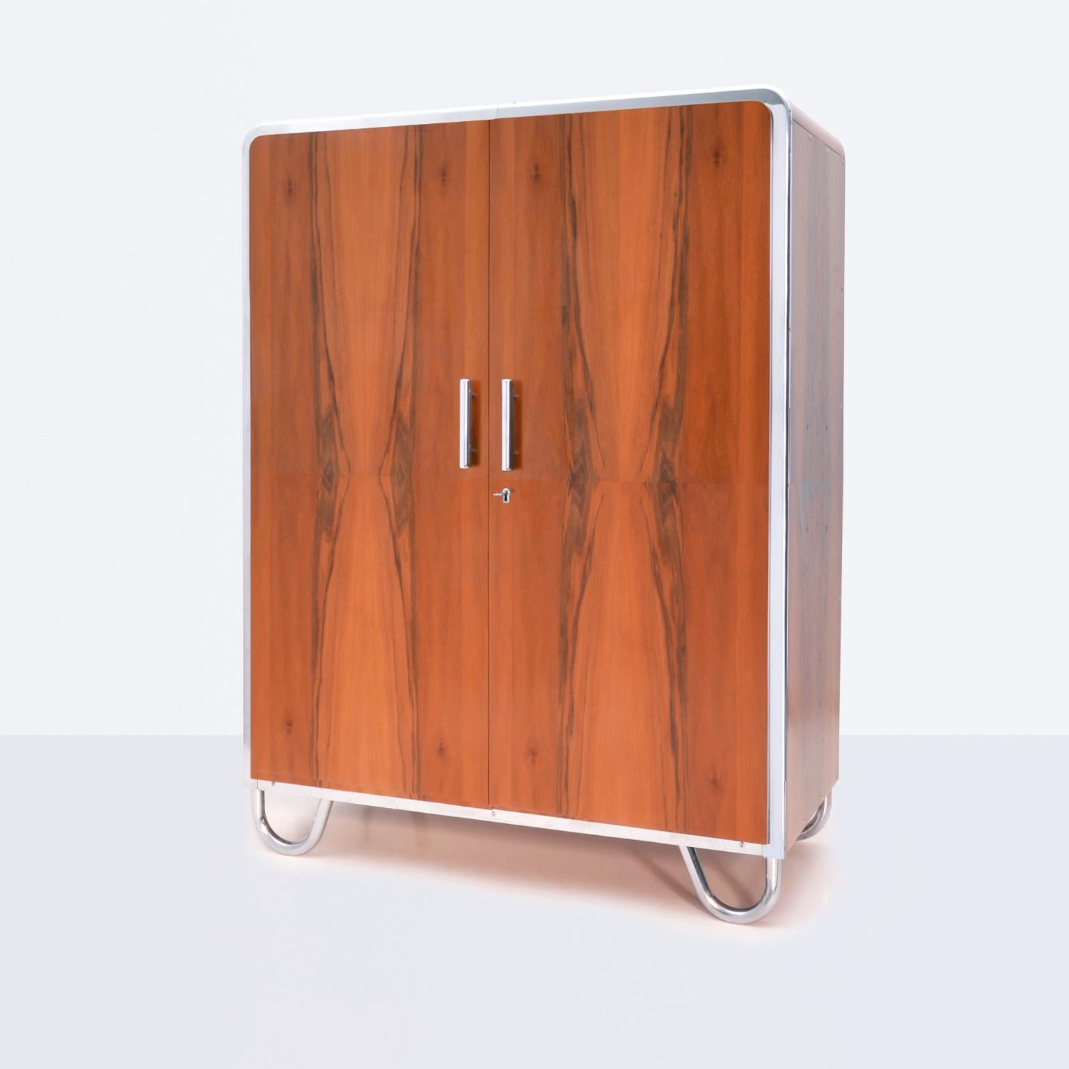 Modernist Cabinet made of chrome plated metal and walnut veneer. Designed and manufactured by Robert Slezak, c. 1930.

Restored on request. Delivery time c. 12-15 weeks.