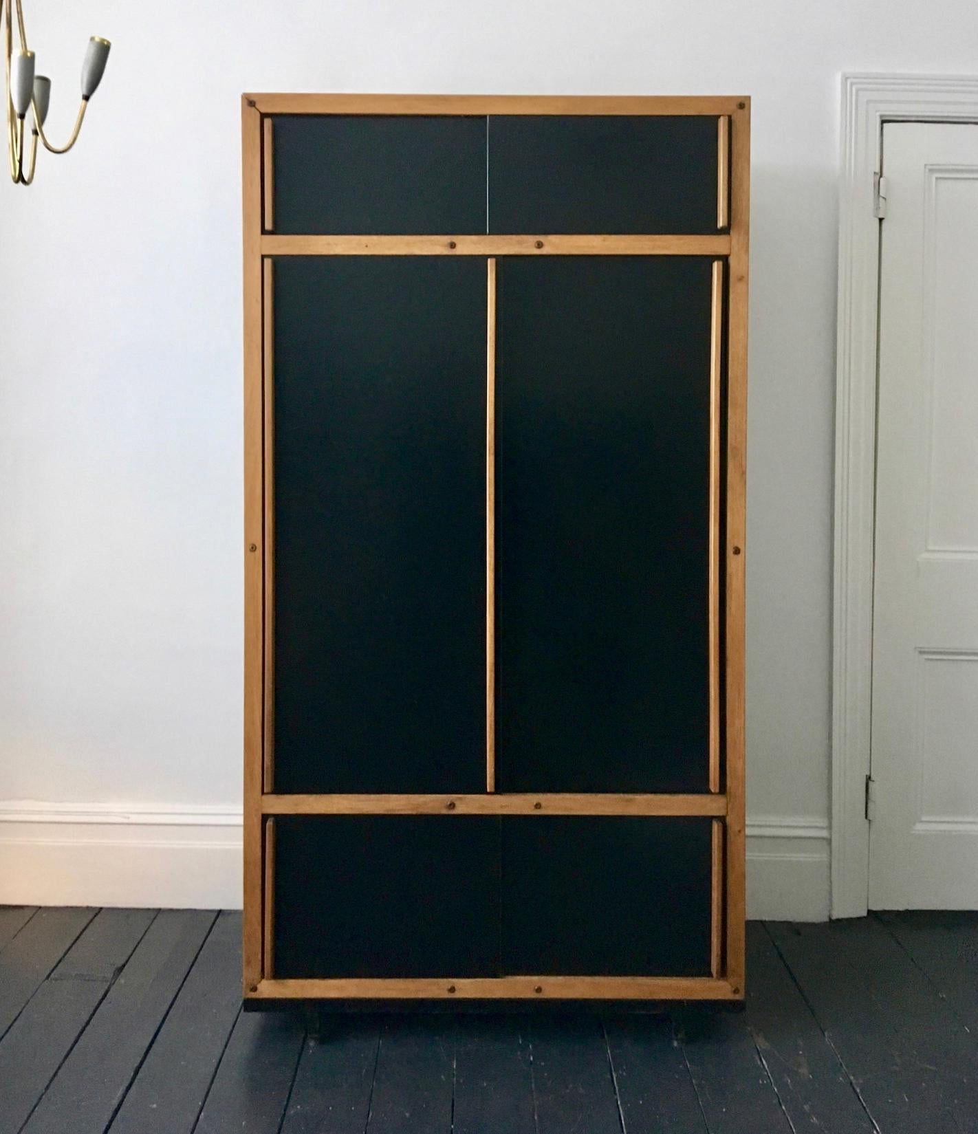 *** Late Summer Sale - ends 30 August ***

Modernist cabinet or armoire by André Sornay, mid-20th century, France. A simple design of clean lines, the main black panels being outlined by the natural wood of the frame and handles of the sliding