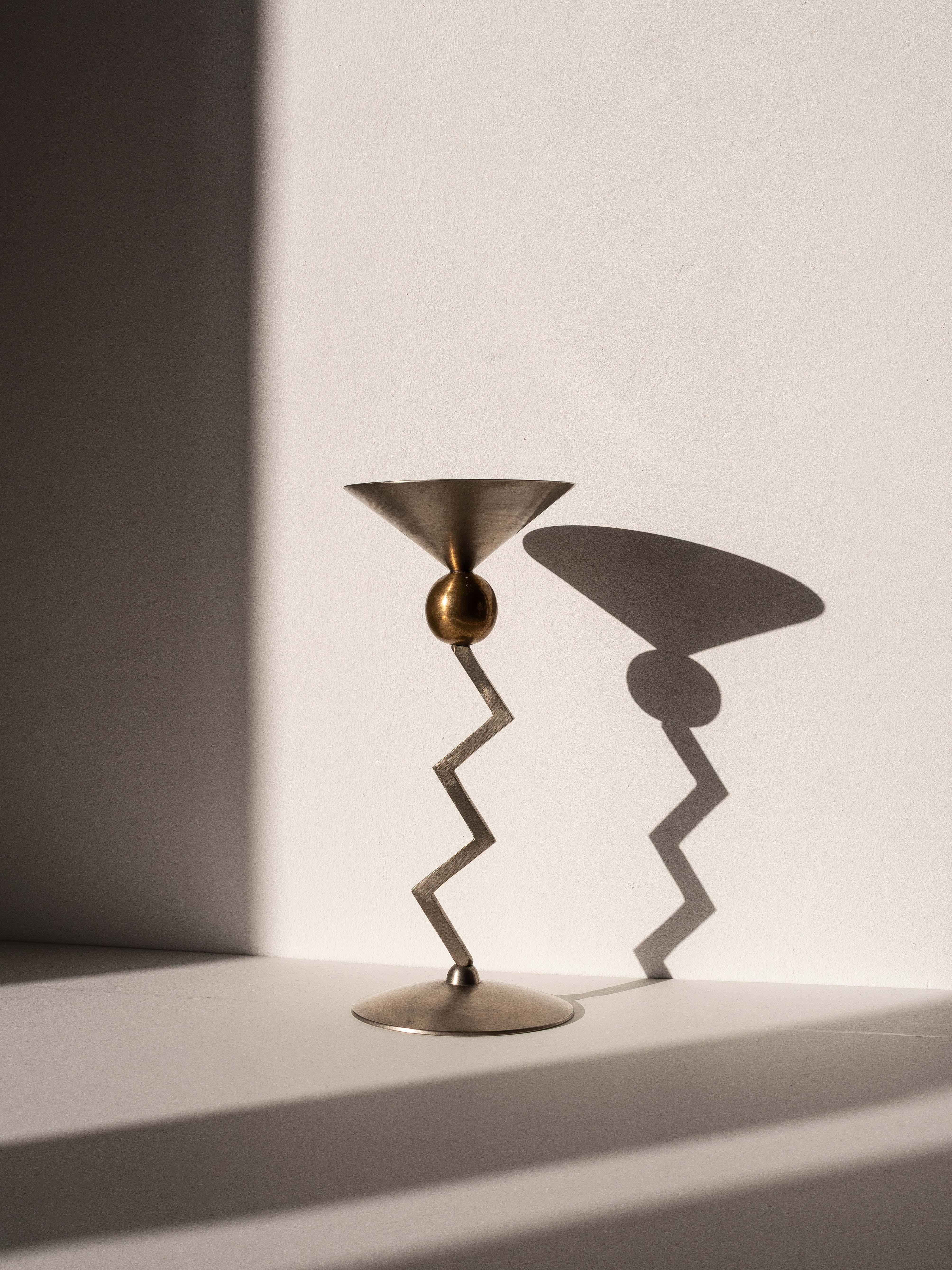 Modernist Kerzenhalter - Edelstahl Brutalist Kerzenständer - Italien 1980er

Hervorragendes Design für dieses Stück, das sehr an den Stil der Memphis-Gruppe erinnert.

Dieser aus Edelstahl und Messing gefertigte Kerzenständer verleiht Ihren Gästen