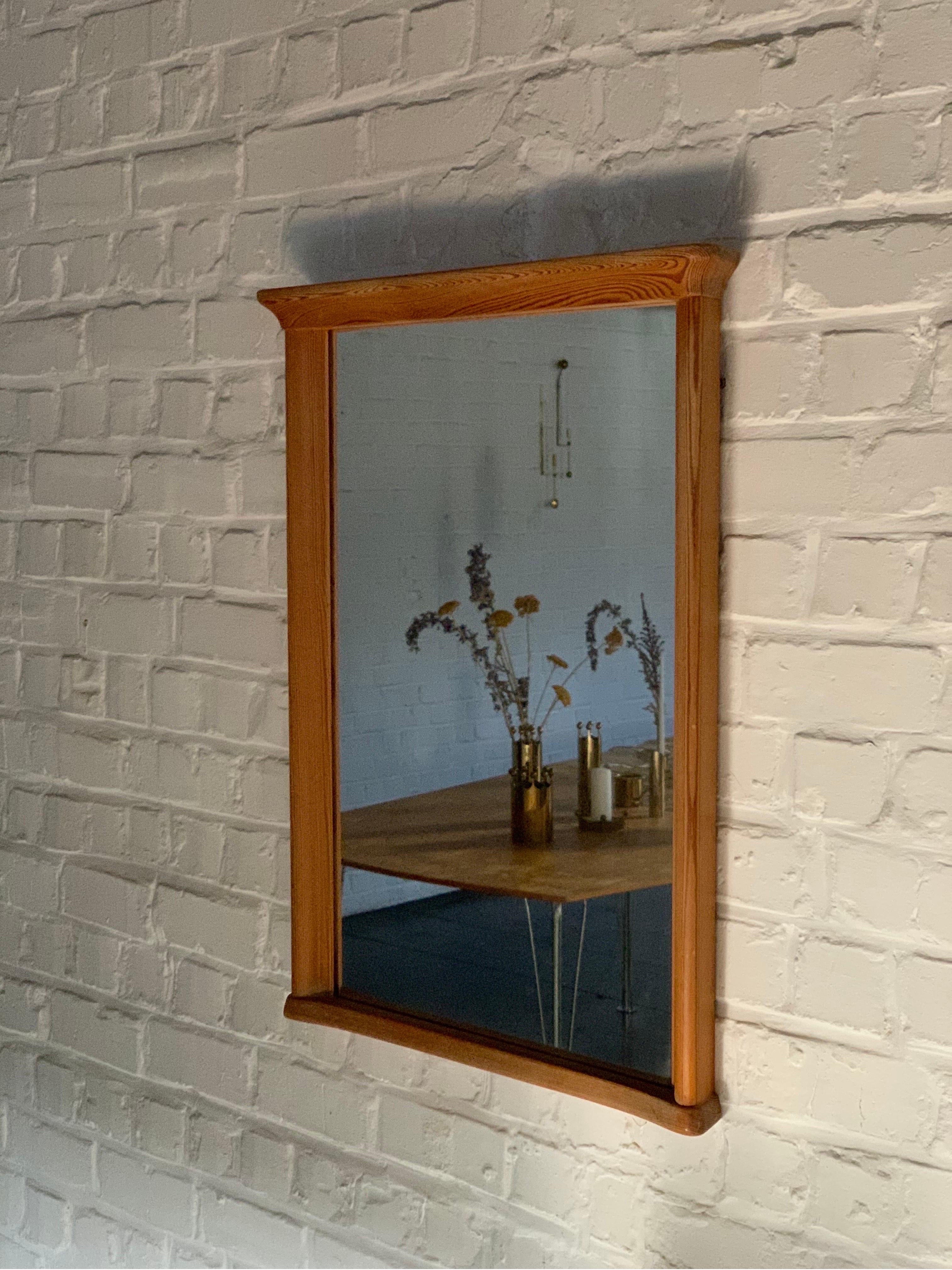 This is an unusual wall pine mirror. Produced in Sweden around the 1940s. It is a so unique in the shape. It will brighten any projects. We just cleaned it and waxed it. Branded with Carl Malmsten signature at the back. Only two screws are necessary