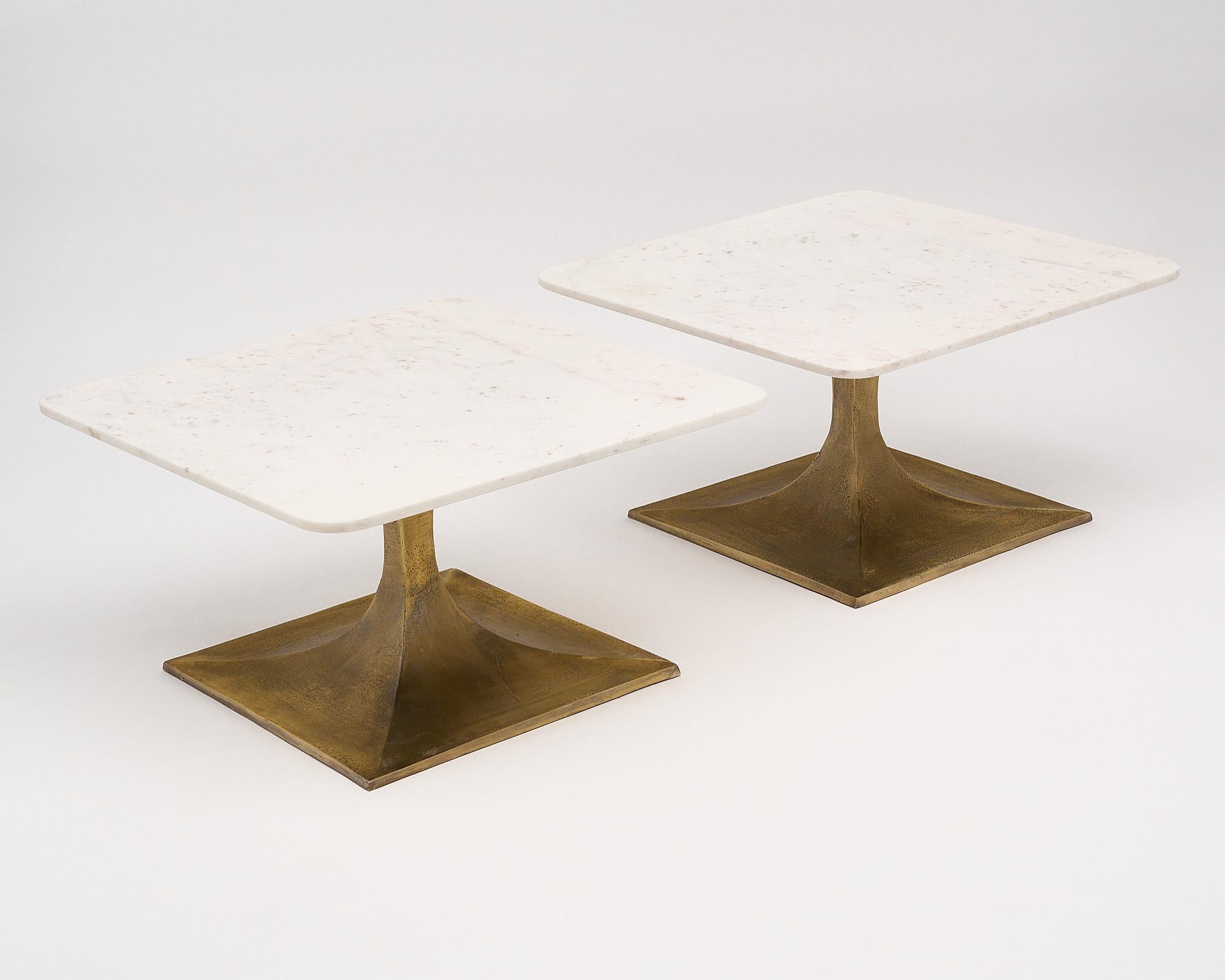 Pair of side tables from France made with bronze tapered bases and Carrara marble slab tops. These tables are originally from the Cartier showroom in Monte Carlo. This square pair has curved corners to bring a softness to the design. We especially
