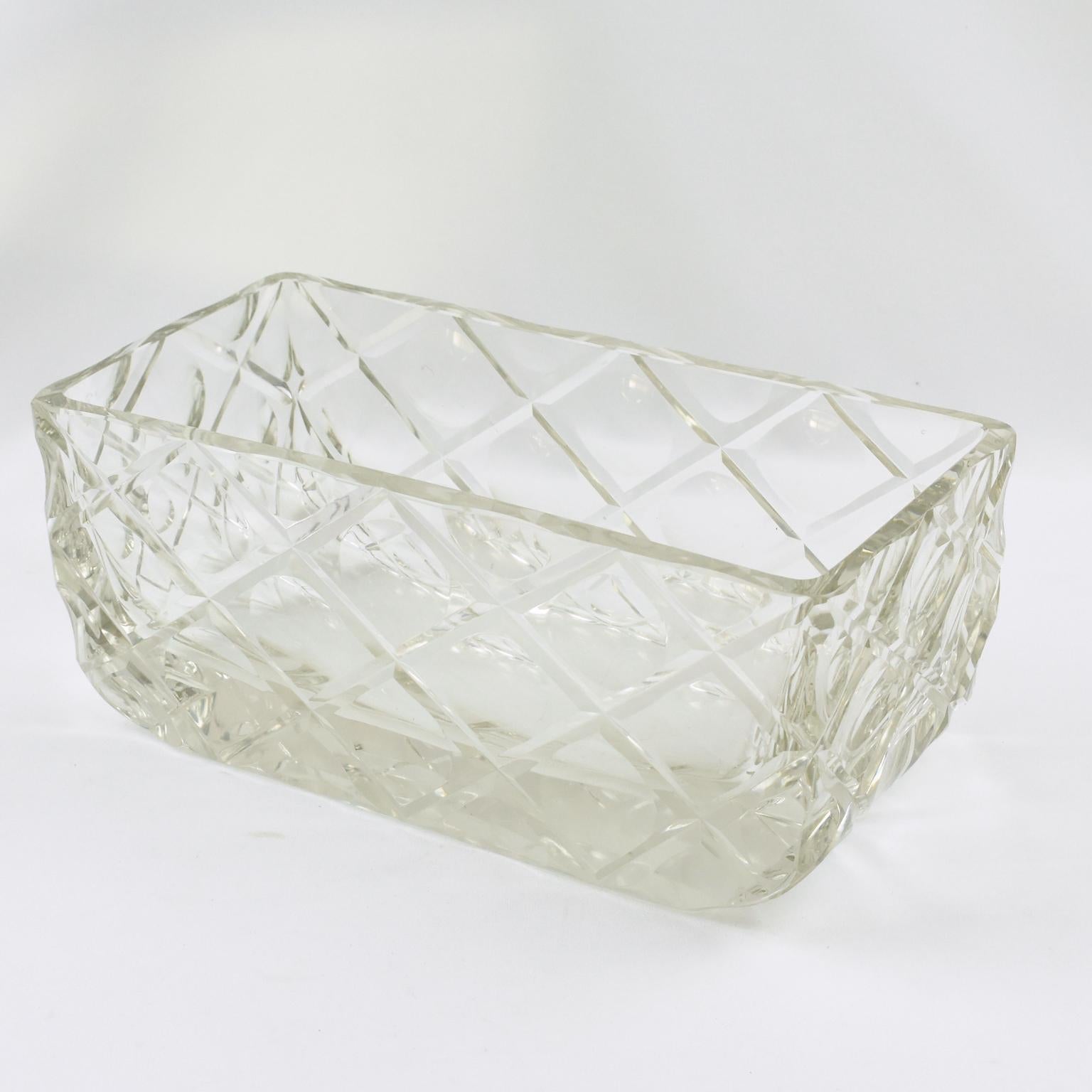 This magnificent sculptural Art Deco crystal centerpiece, crafted in France circa 1930, exudes sophistication and artistic excellence. Its sleek, streamlined rectangular form is elevated by exquisite deep geometric hand-carved etchings, creating a