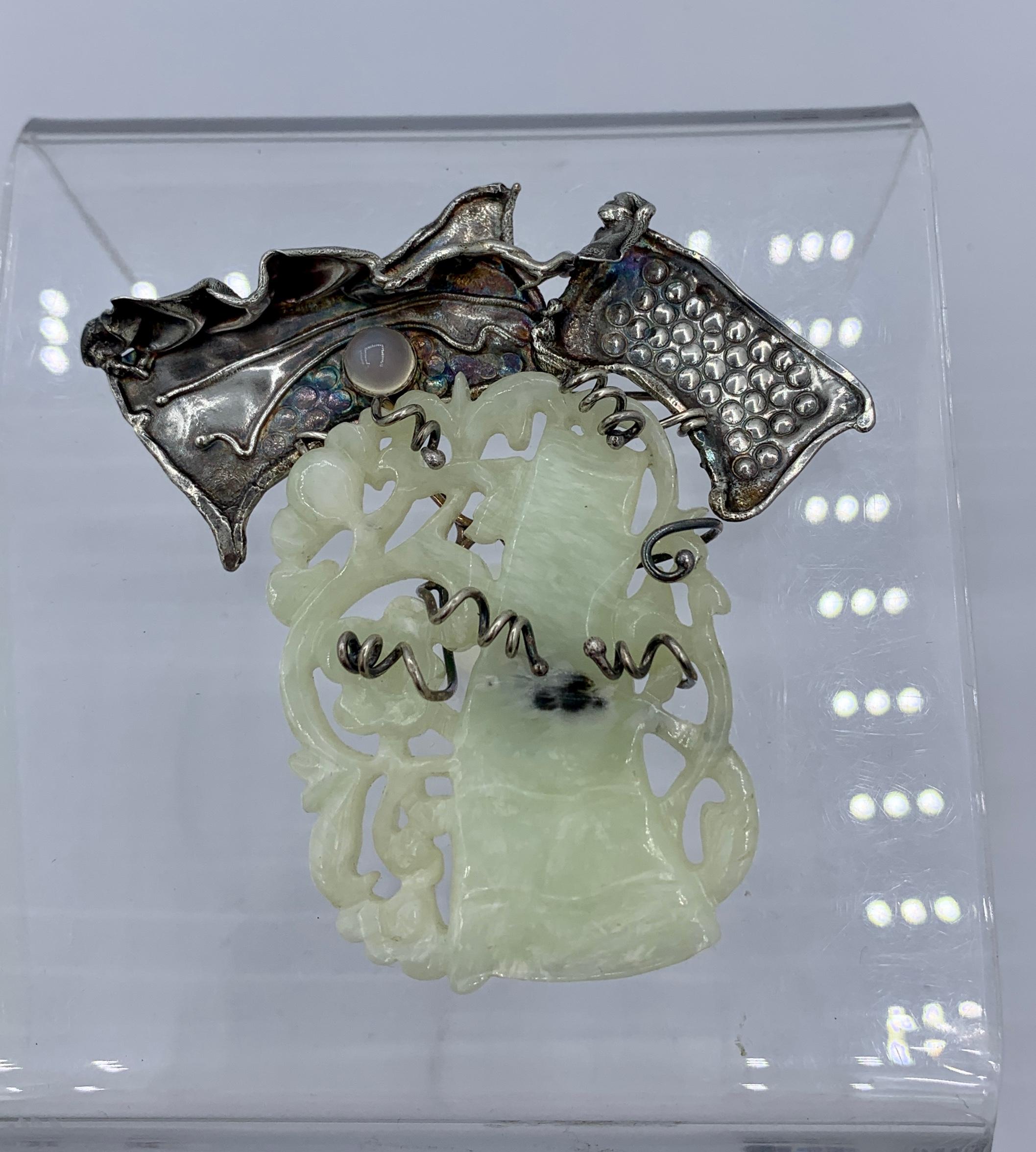 This is a stunning Modernist Brooch Pin with a wonderful hand carved Jade center with images of a tree with fruit.  The wonderful open work Jade is set within curling silver branches.  The top of the brooch is a brutalist freeform nature inspired