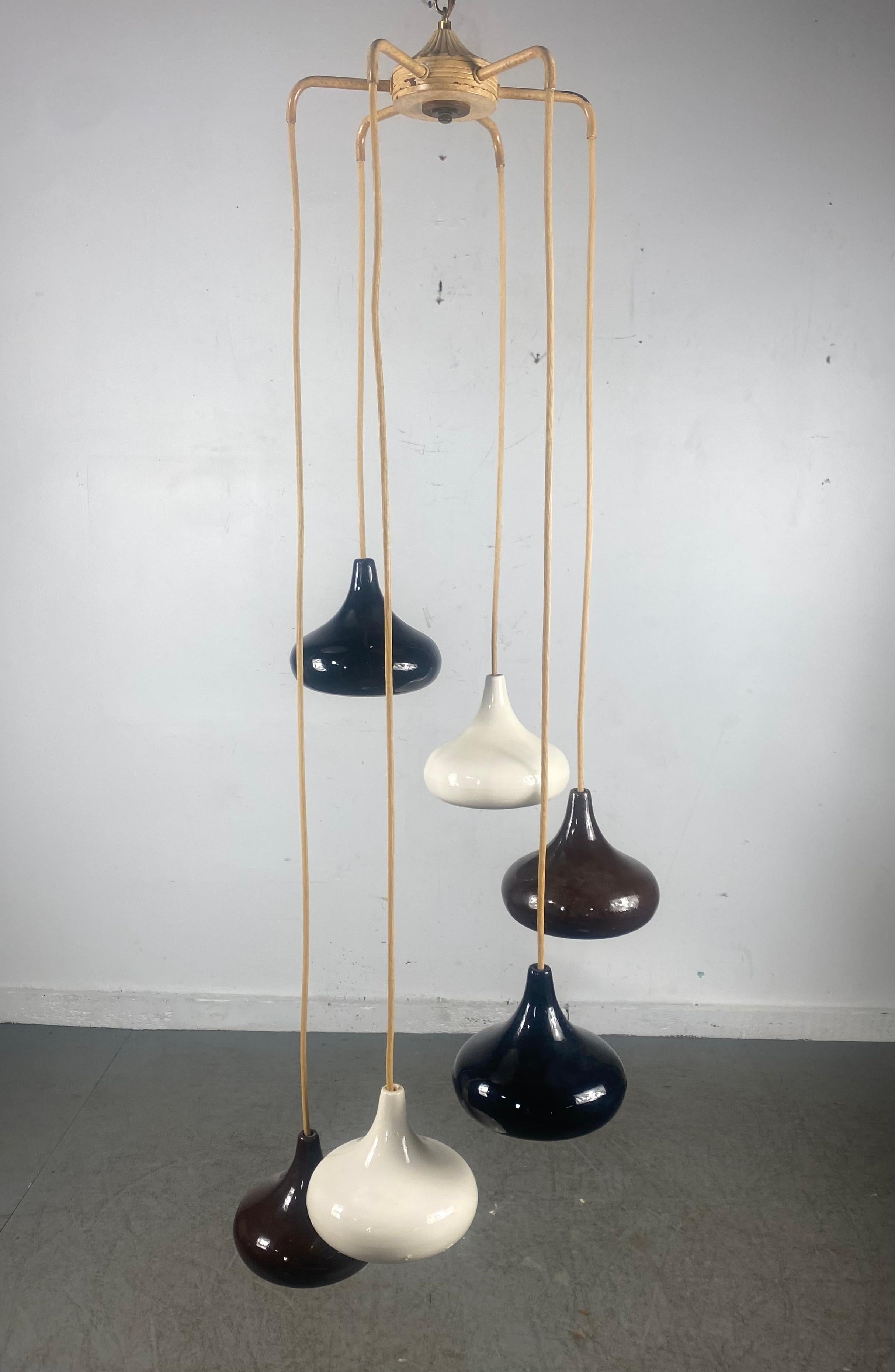 Stunning cascading ceramic pendant light consisting of 6 graduating (hersey kiss) shape fixtures of white, black and chocolate brown, tested and electrical working, individual lamps measure 6.5 x 7 in diameter.